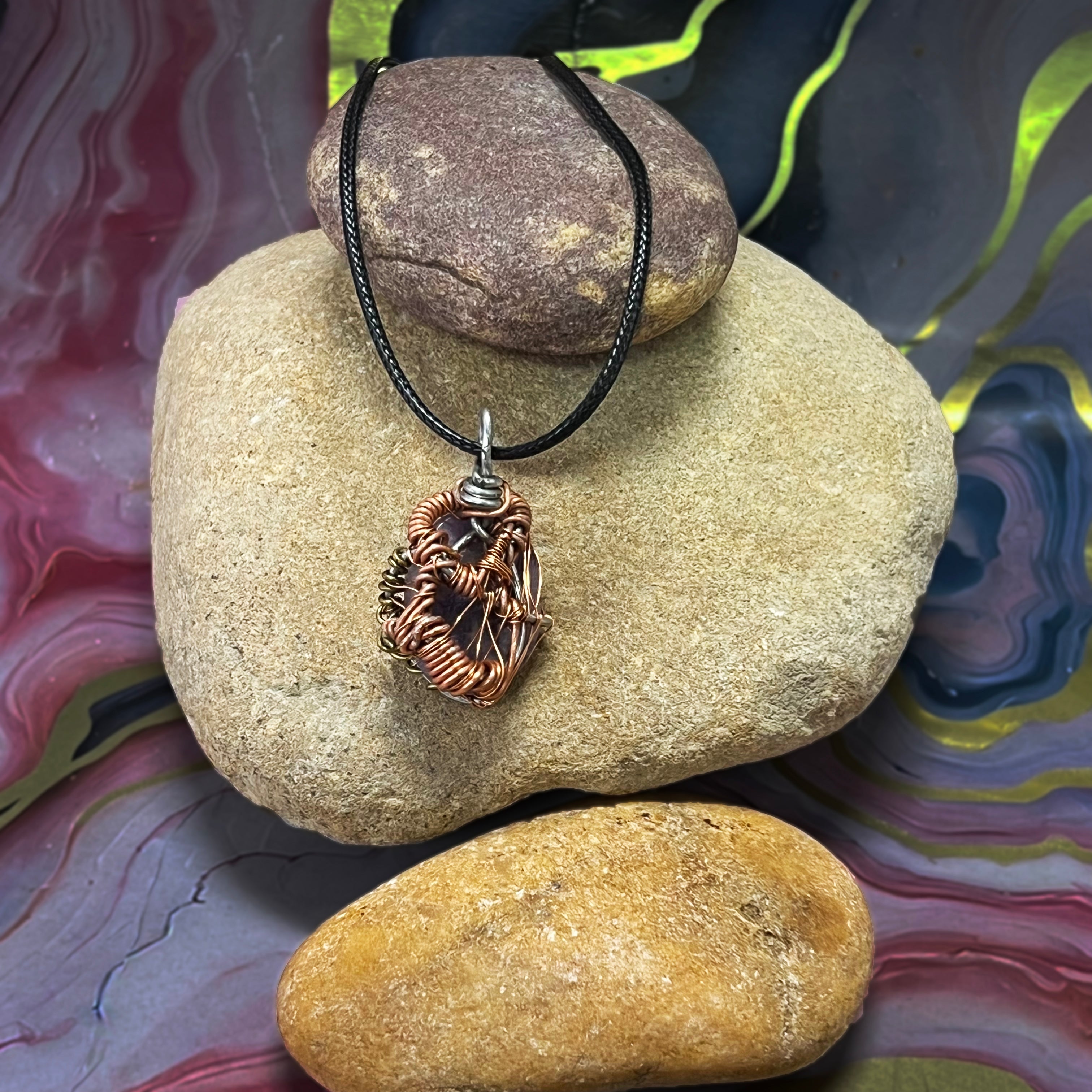 Close-up of lavender-toned Lepidolite beads showing organic wire wrap detail and textured surface from a slight top-down