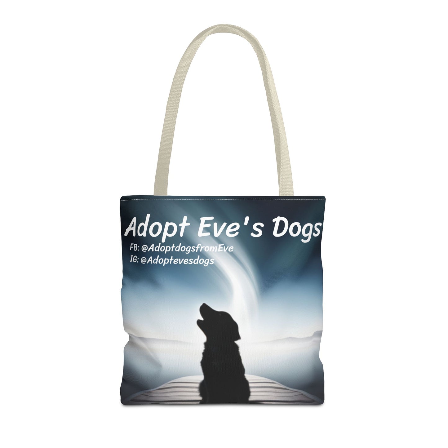 This is the Beige 16" x 16" Adopt Eve's Dogs Tote with color matched handles. This is an all around print tote with "Adopt Eve's Dogs" and socials on the top in white. The print is of a shadow of a golden retriever looking to the left on a pier towards water with mountains surrounding it. The tote is against a white background.