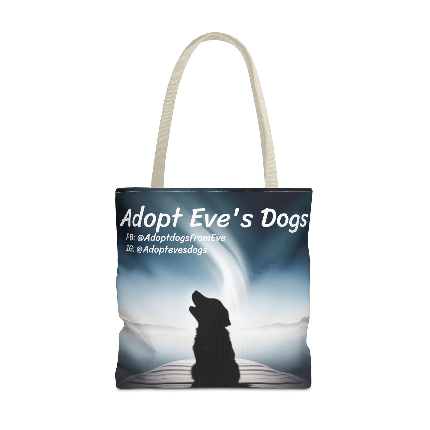 This is the Beige 18" x 18" Adopt Eve's Dogs Tote with color matched handles. This is an all around print tote with "Adopt Eve's Dogs" and socials on the top in white. The print is of a shadow of a golden retriever looking to the left on a pier towards water with mountains surrounding it. The tote is against a white background.