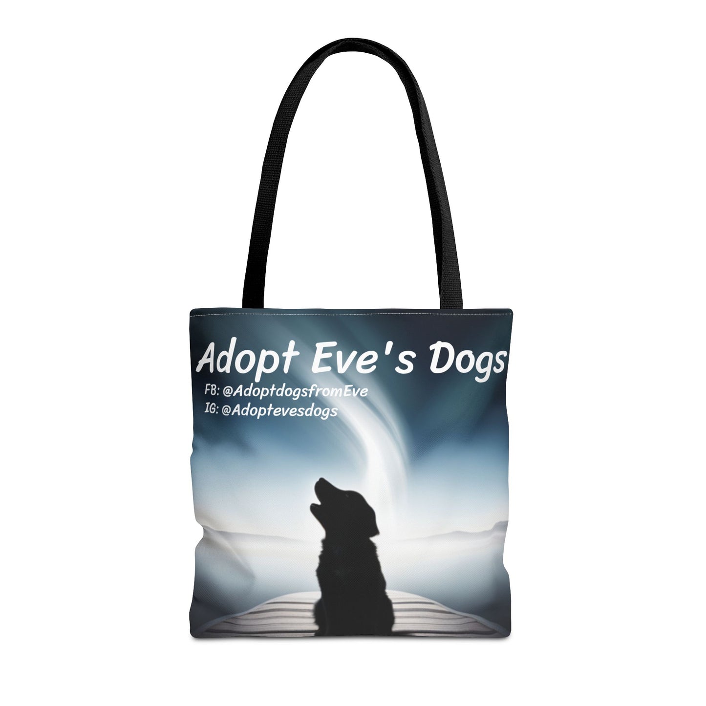 This is the Black 16" x 16" Adopt Eve's Dogs Tote with color matched handles. This is an all around print tote with "Adopt Eve's Dogs" and socials on the top in white. The print is of a shadow of a golden retriever looking to the left on a pier towards water with mountains surrounding it. The tote is against a white background.