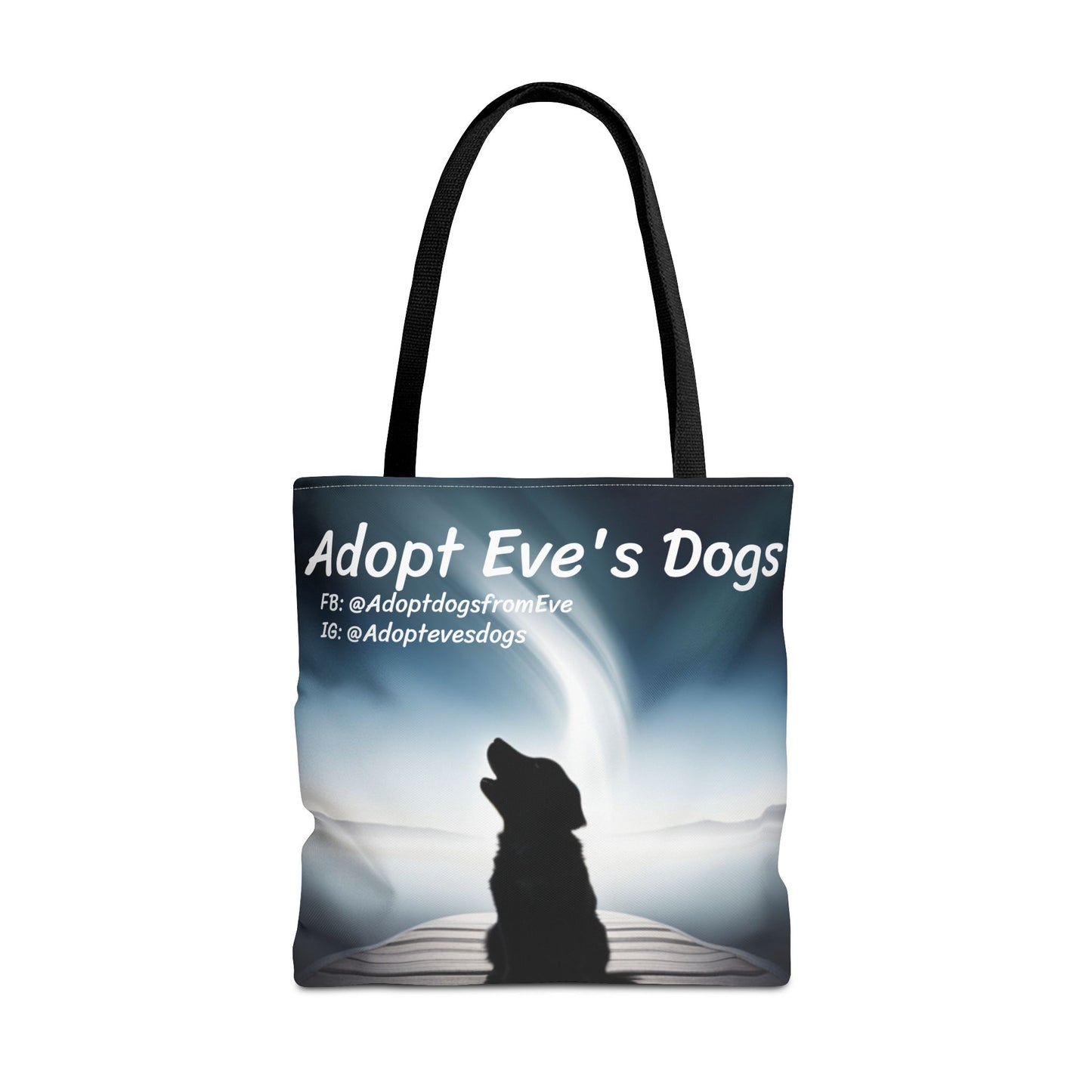 This is the Black 18" x 18" Adopt Eve's Dogs Tote with color matched handles. This is an all around print tote with "Adopt Eve's Dogs" and socials on the top in white. The print is of a shadow of a golden retriever looking to the left on a pier towards water with mountains surrounding it. The tote is against a white background.