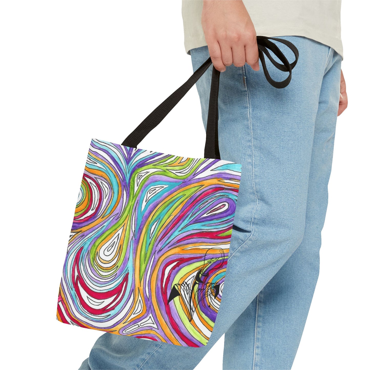This is the Black 13" x 13" Oil Spill Tote Bag by Storm Garden Studio. The tote has color matched straps, abstract colors and line work, all over print. The colors are lime green, orange, light blue, dark red, purple, white and black. Storm Garden Studio logo printed in black on bottom right of tote bag. A gentleman wearing a white shirt, jeans and turned to the right is holding the tote by the handles. The image is from the hip down. The tote is against a white background.