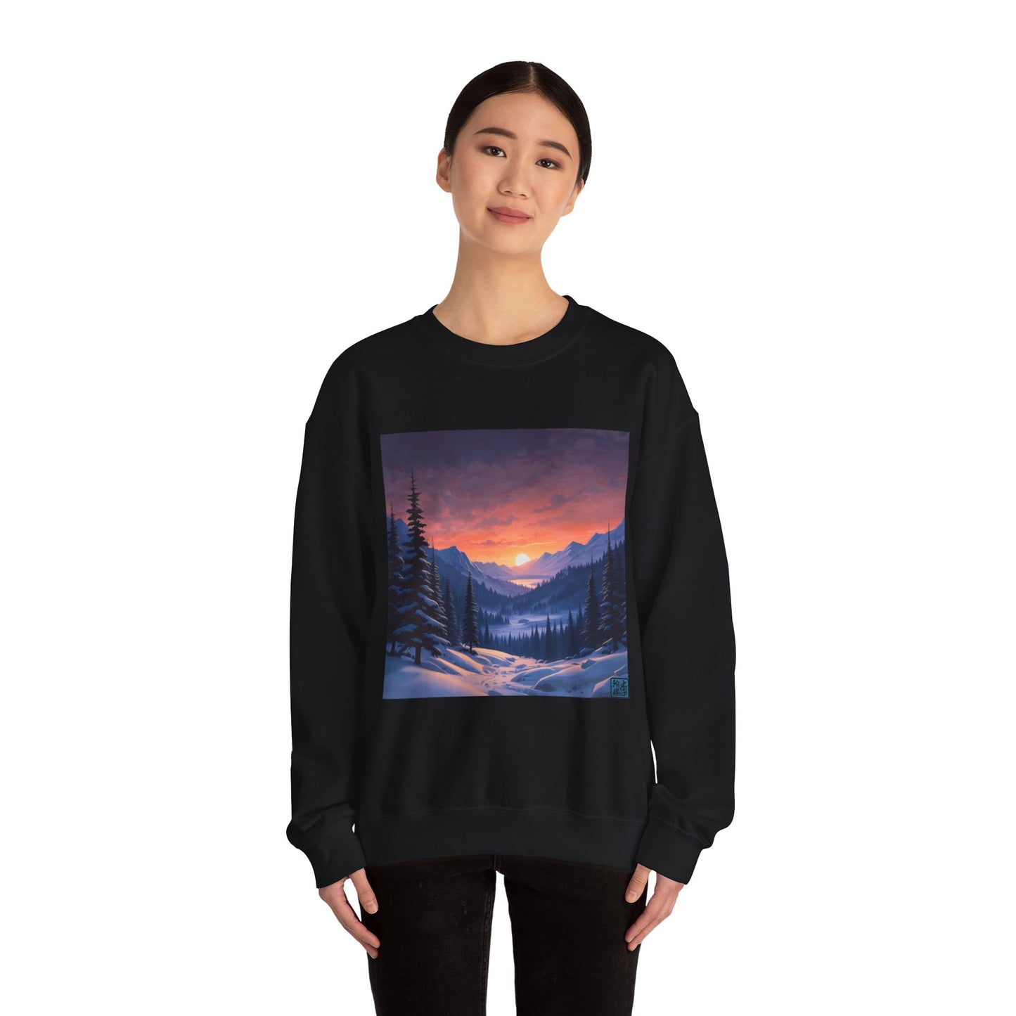 This is the Black Snow Valley Sweatshirt that is a crewneck coming in S - 5XL sizes. It is worn by an Asian lady who has black hair tied in a bun, black pants and is standing against a white background with a smile. This design is by Lee Hansheng Studios and showcases a snowy hill/mountain area with large pine trees on both sides continuing into the horizon. The sun is rising past the horizon and consist of yellow, orange, red hues which is illuminated onto the clouds, snowy field, mountains and trees.