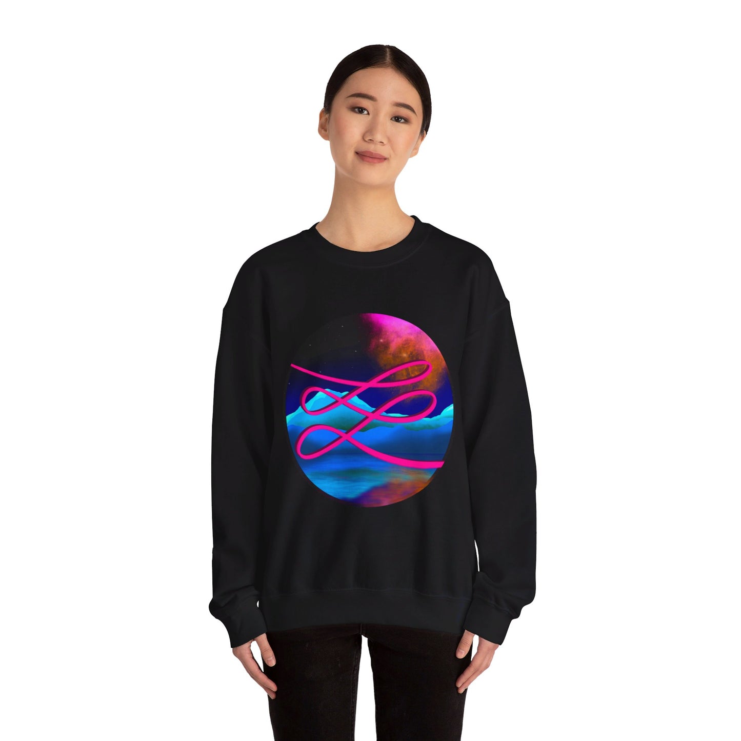 This is the Black Swirl Heavy Blend Crewneck Sweatshirt by Lee Hansheng Studios. It comes in sizes S-3XL. The illustration is circular and covers the front of the shirt. The design is a hot pink swirl from left to right. The background has a mountain landscape that is reflected. The colors are pink, black, orange and blue. A lady with a smile, black hair tied up and black jeans is standing wearing the sweatshirt with her hands to the sides. She is against a white background.