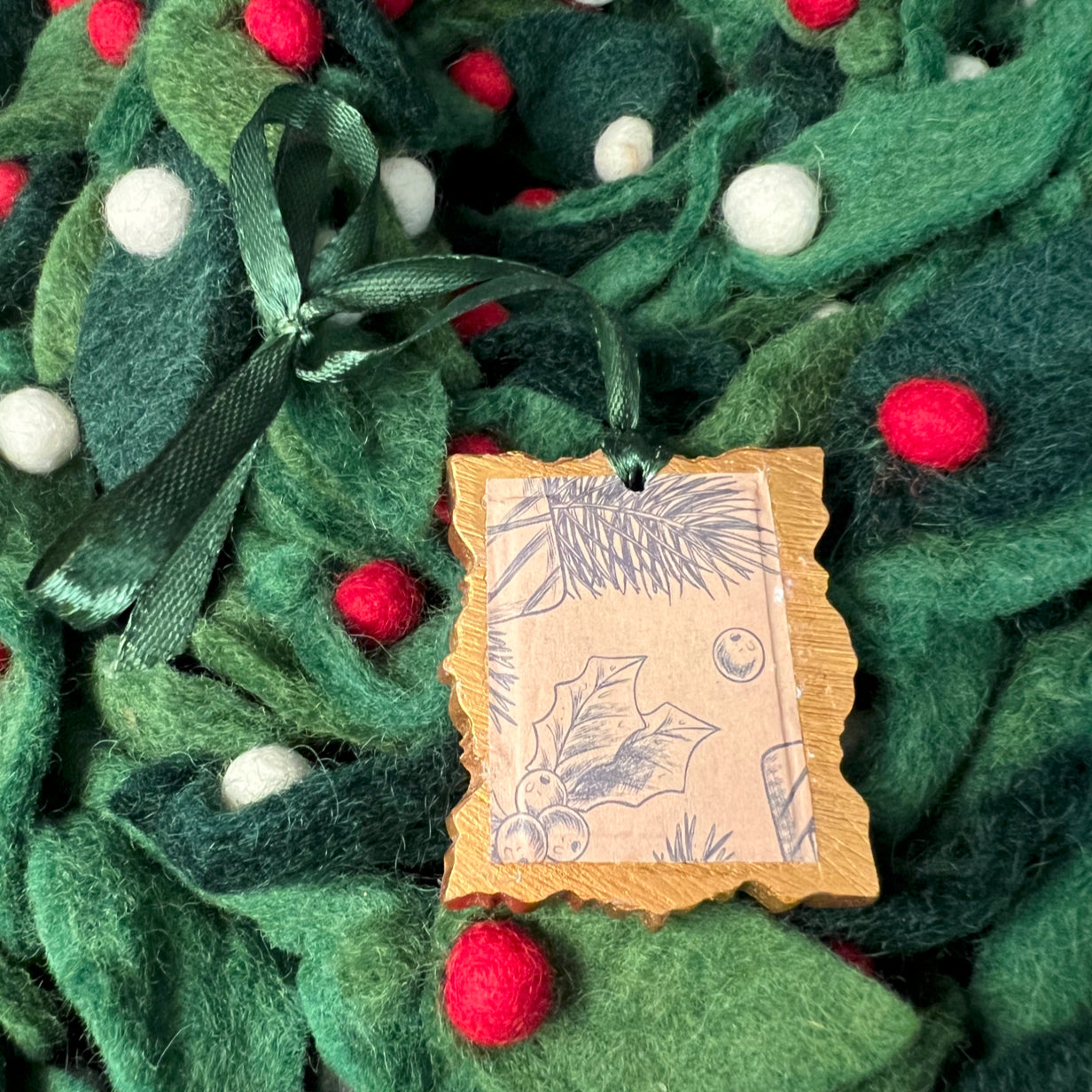 Close-up of the textured red felt surface with silver glitter accents on the Christmas Tree rectangle ornament's edge.