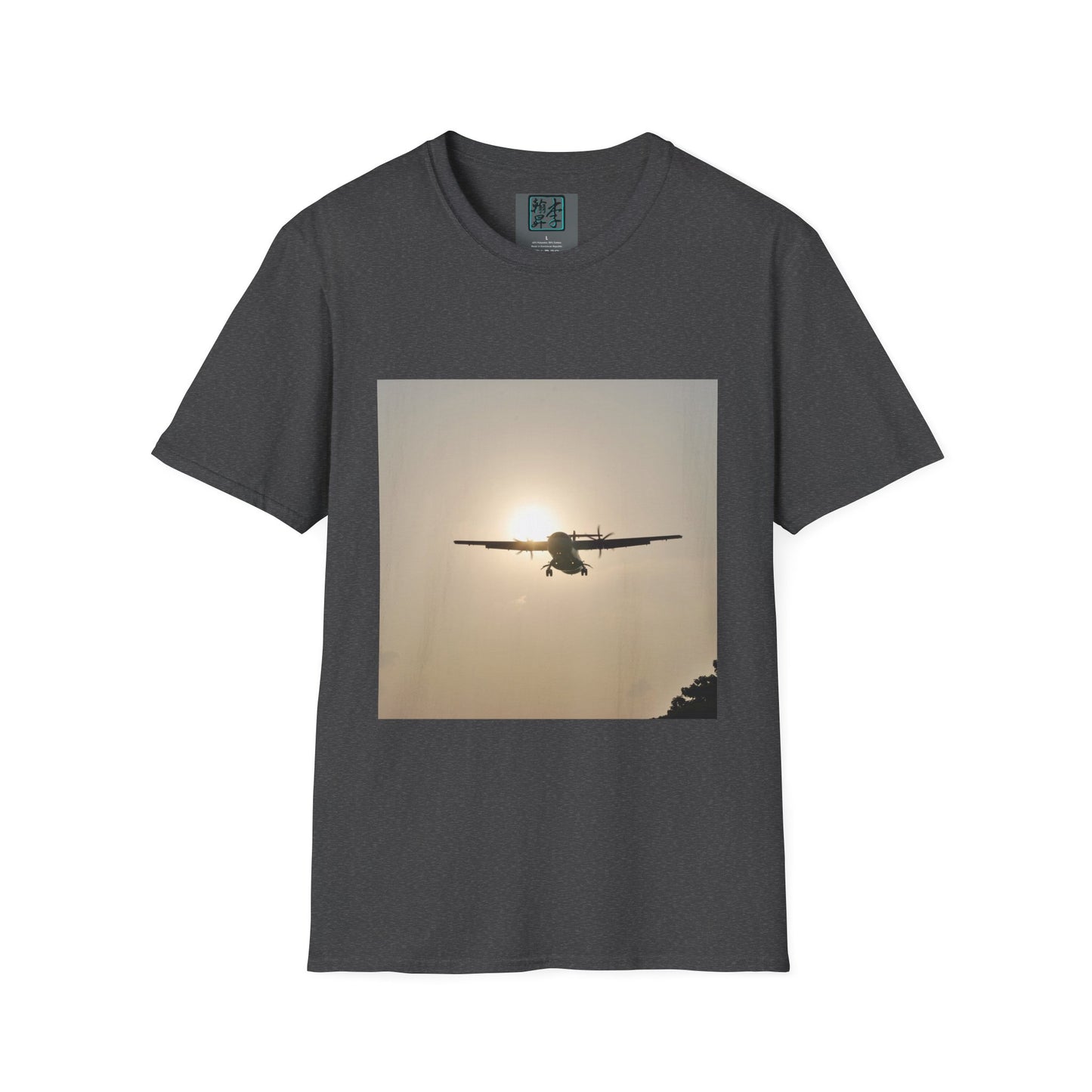 This is the Dark Heather Landing T-Shirt by Lee Hansheng Studios. This is an image of the front folded. On the inside of the shirt is the logo for the studio printed in black outlined in blue, gray size label with the print being white. The illustration is a rectangular design of an airplane landing. There is an orange/yellow sun with the shadowed plane. Some trees on the right end corner. The shirt is against a white background.