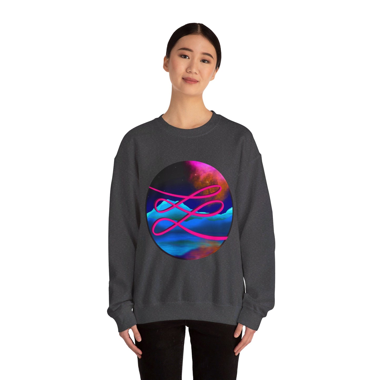 This is the Dark Heather Swirl Heavy Blend Crewneck Sweatshirt by Lee Hansheng Studios. It comes in sizes S-3XL. The illustration is circular and covers the front of the shirt. The design is a hot pink swirl from left to right. The background has a mountain landscape that is reflected. The colors are pink, black, orange and blue. A lady with a smile, black hair tied up and black jeans is standing wearing the sweatshirt with her hands to the sides. She is against a white background.