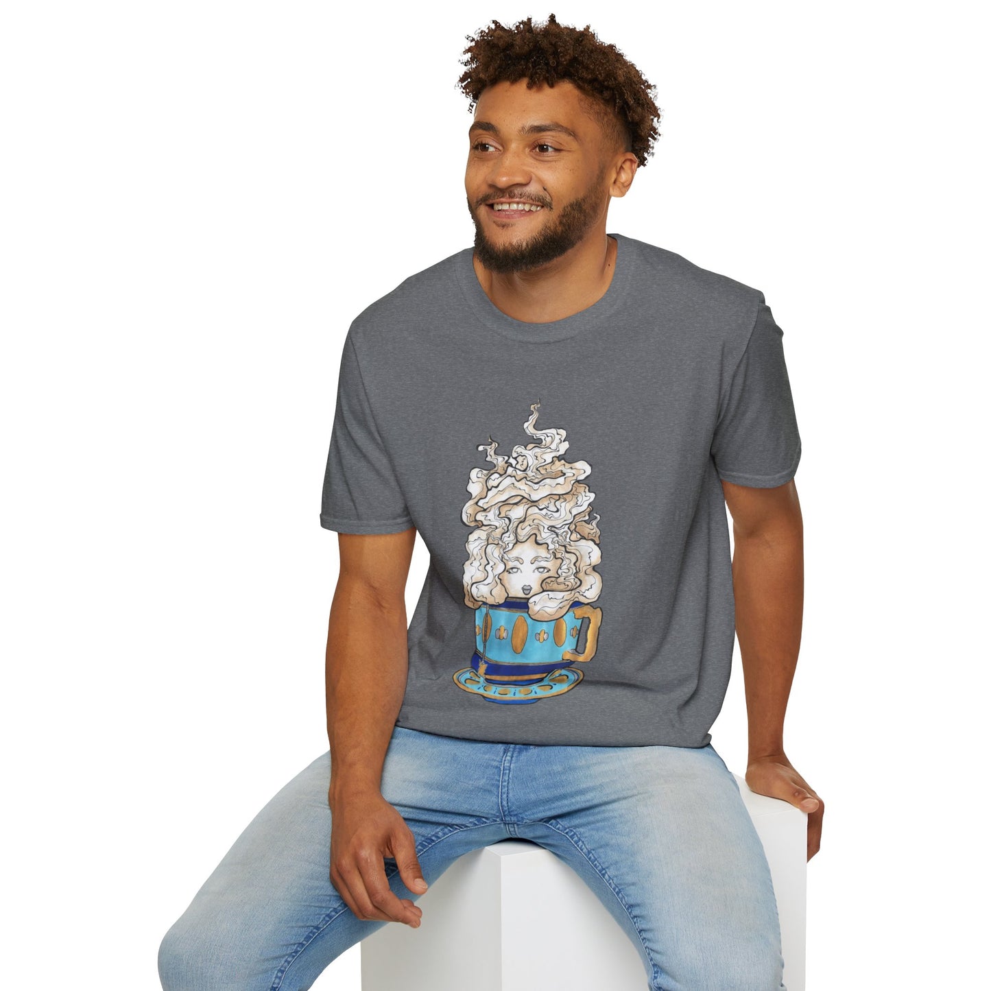 This is the Graphite Heather Grey Earl Grey Softstyle T-Shirt by Chris Foster Design. It comes in sizes XS-5XL. The illustration is of a gold, light blue and dark blue teacup with a tan, yellow and white steam. The steam is swirly and goes up and outwards. In the middle is a lady's face. A smiling man sitting on a white podium with one hand on the back edge, light jeans, looking to the left and wearing the t-shirt.