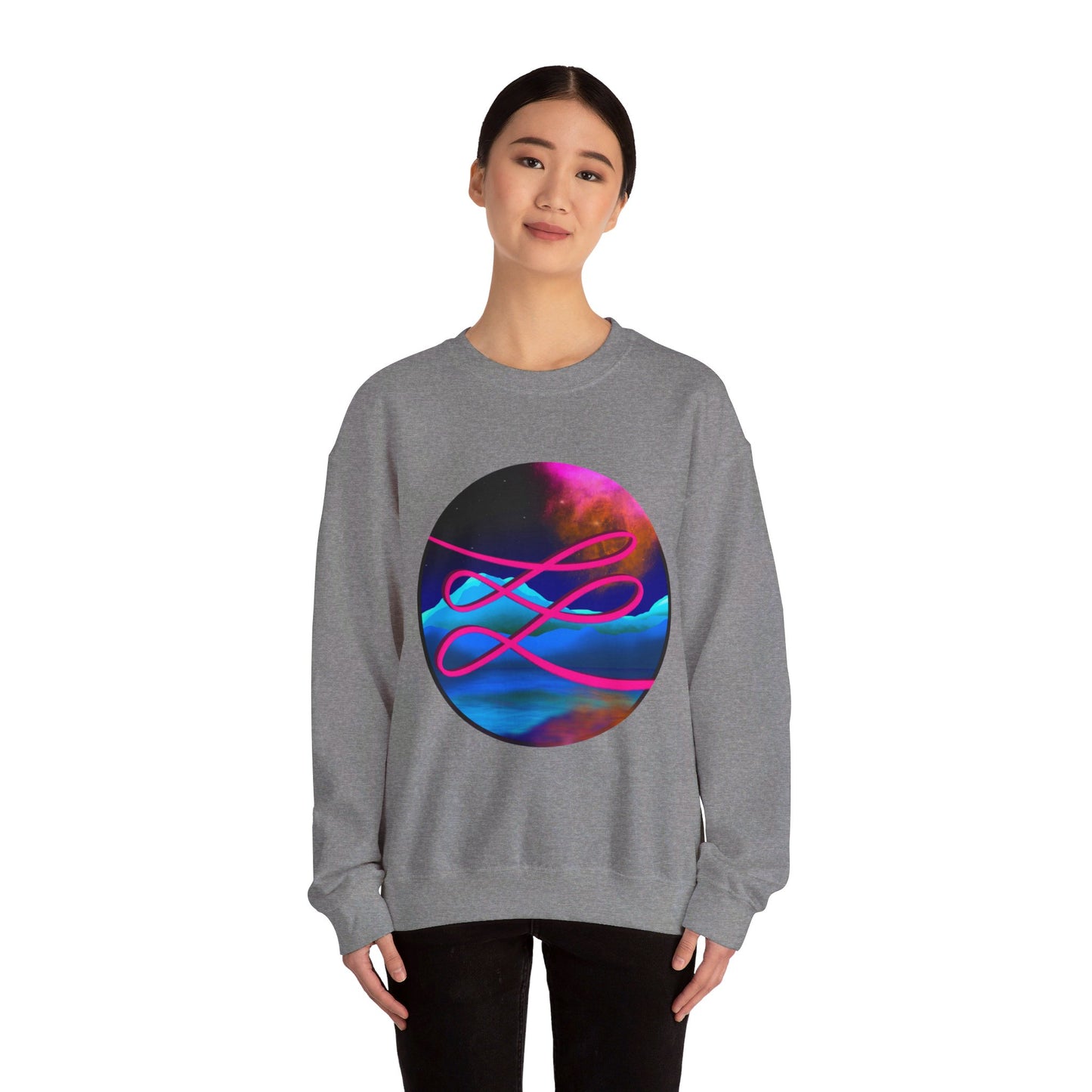 This is the Graphite Heather Swirl Heavy Blend Crewneck Sweatshirt by Lee Hansheng Studios. It comes in sizes S-3XL. The illustration is circular and covers the front of the shirt. The design is a hot pink swirl from left to right. The background has a mountain landscape that is reflected. The colors are pink, black, orange and blue. A lady with a smile, black hair tied up and black jeans is standing wearing the sweatshirt with her hands to the sides. She is against a white background.