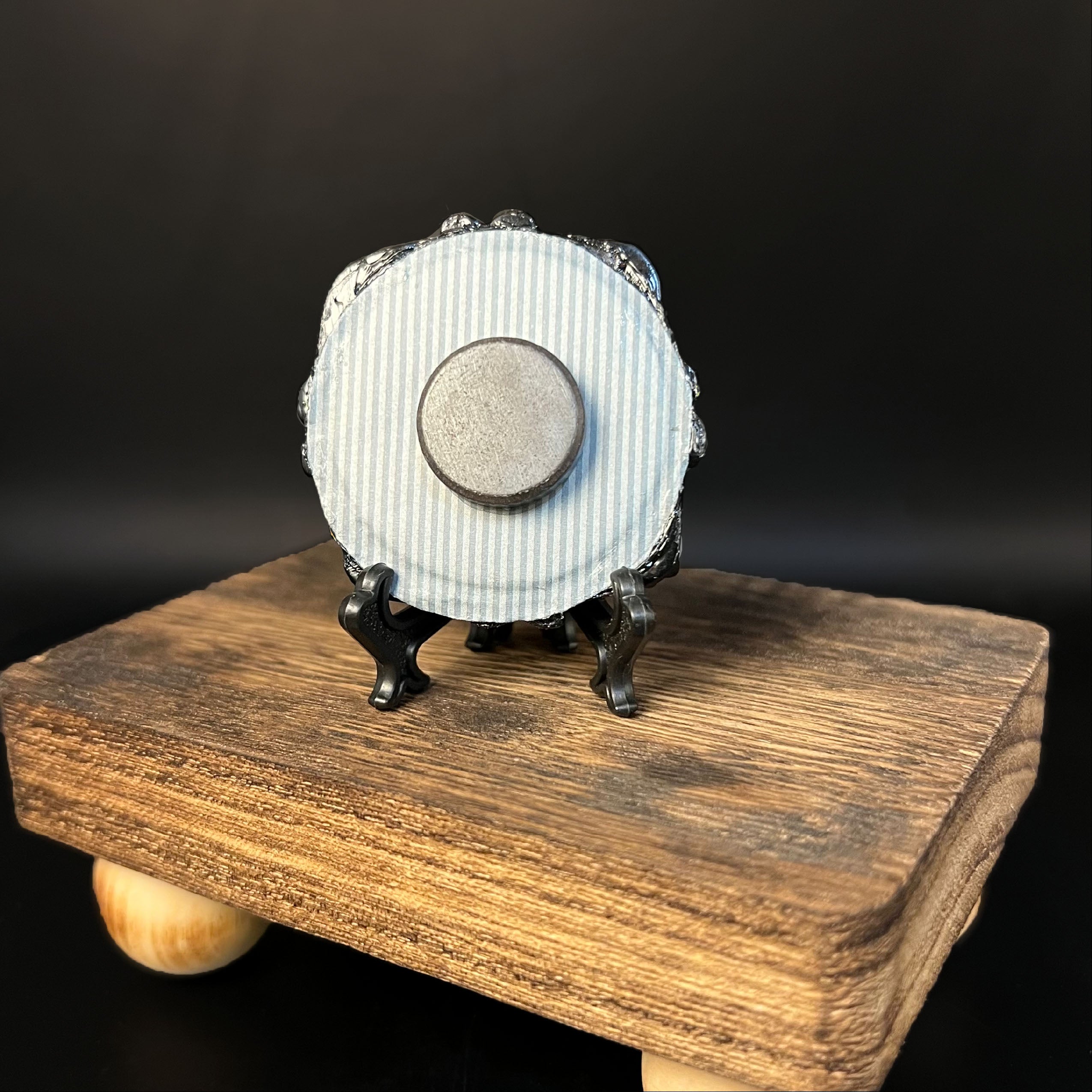 Close-up of the intricate green bat miniature’s textured surface and finely painted details from a top-down perspective