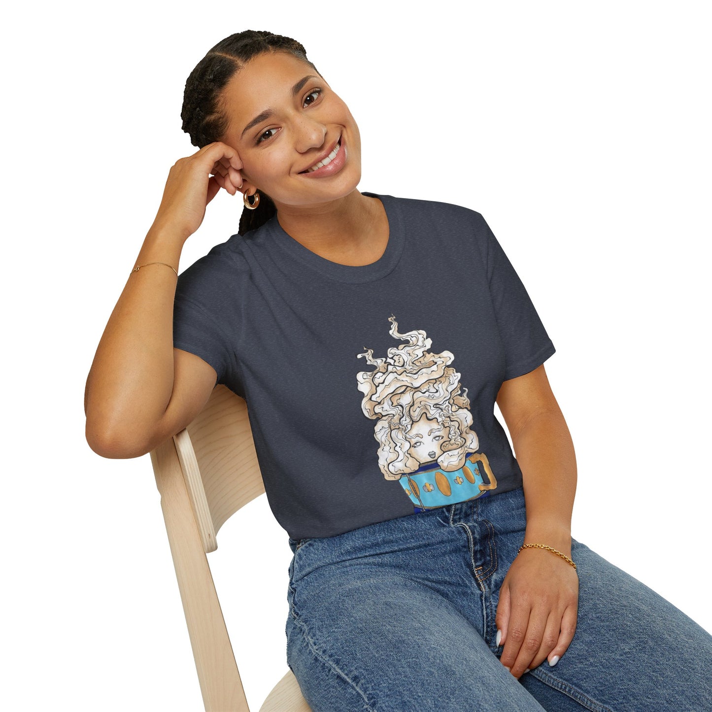 This is the Heather Navy Earl Grey Softstyle T-Shirt by Chris Foster Design. It comes in sizes XS-5XL. The illustration is of a gold, light blue and dark blue teacup with a tan, yellow and white steam. The steam is swirly and goes up and outwards. In the middle is a lady's face. A smiling lady is sitting on a light wood chair with the backrest to the left, elbow on the back rest, dark jeans, looking to the front and wearing the t-shirt.