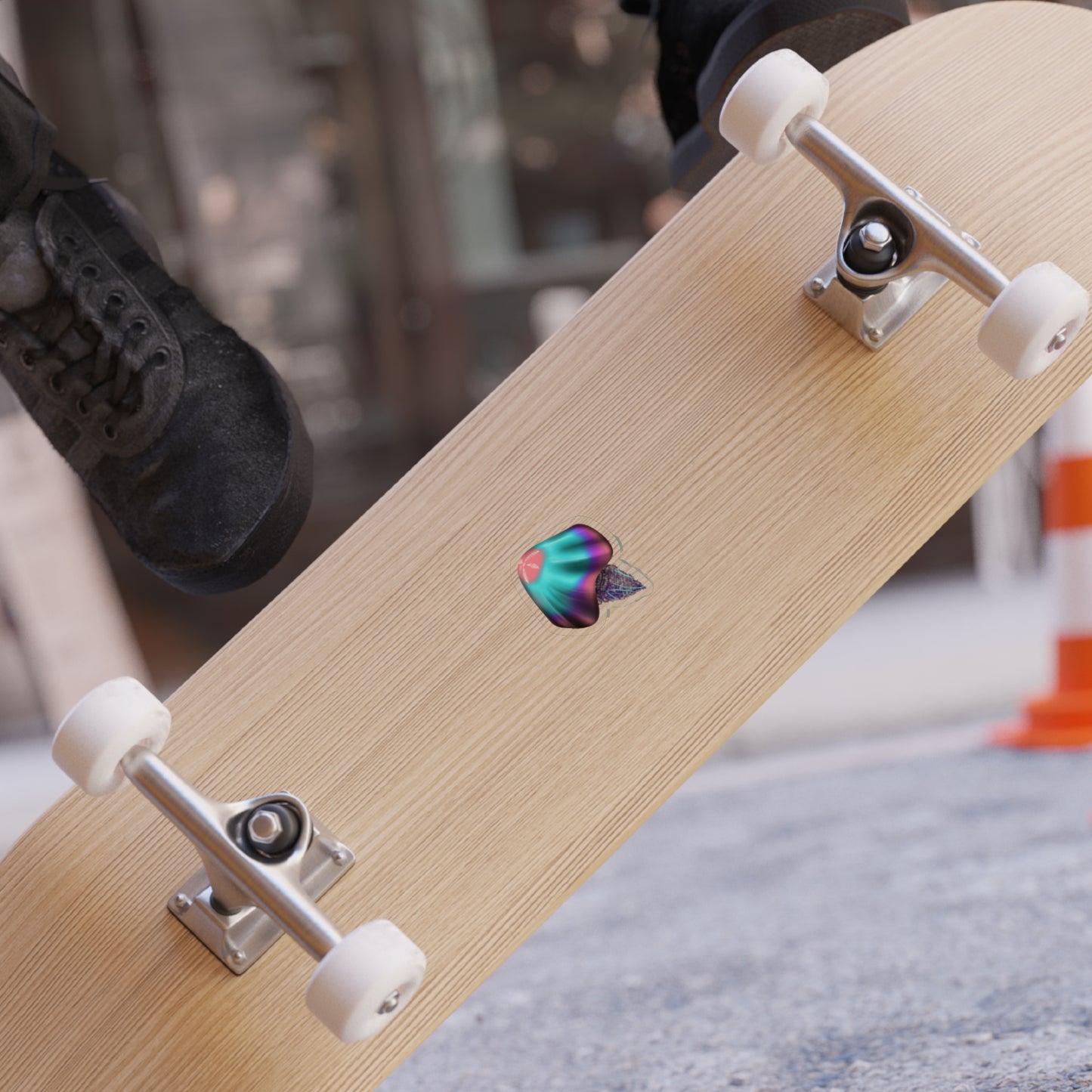 A 2" x 2" die cut transparent pink, blue, purple sticker on a skateboard.