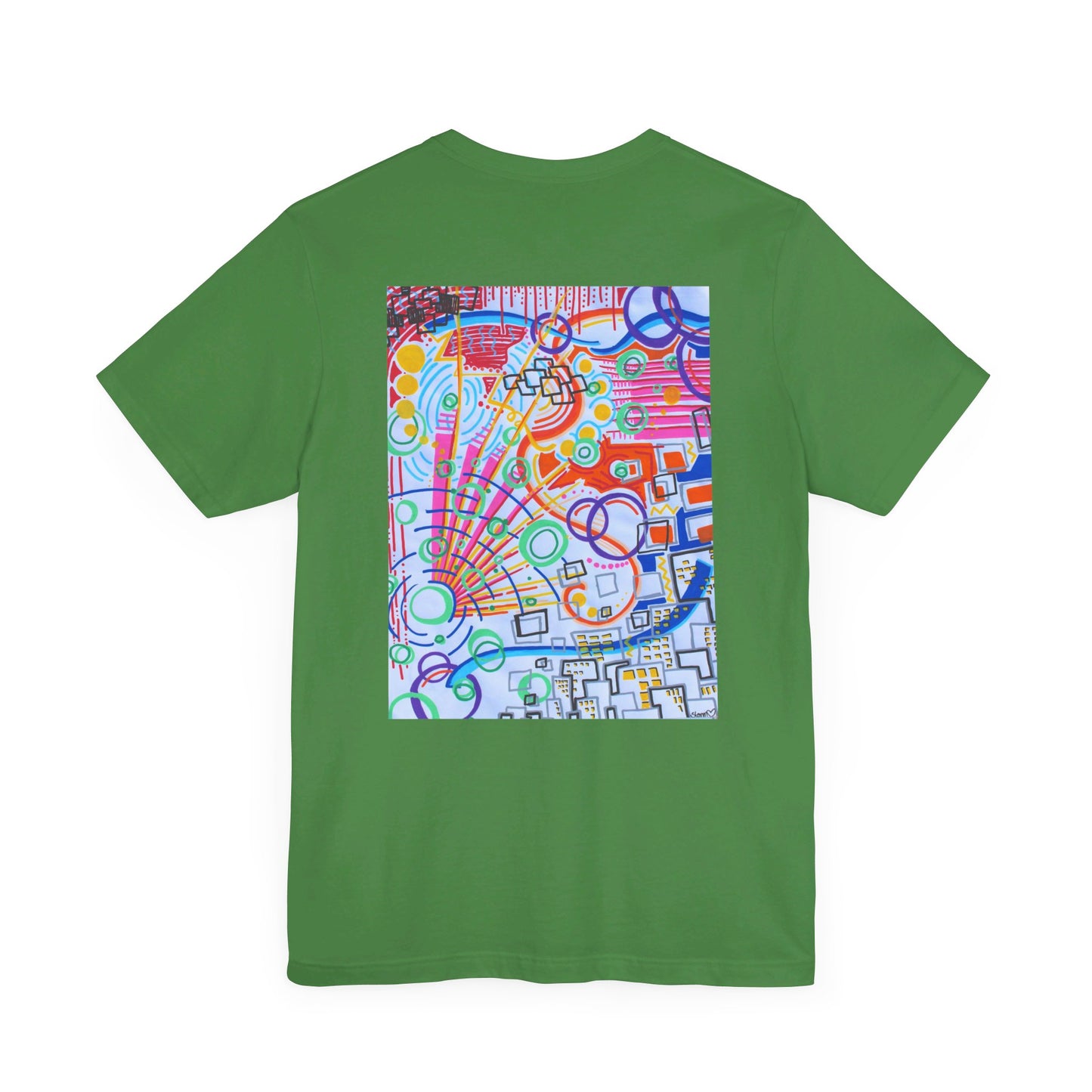 This is the Leaf The City Jersey T-Shirt by Storm Garden Studio. This showcases the back of the shirt. The image is from the upper back to the mid waist. The illustration is rectangular shaped and has a multitude of colors like blue, red, pink, yellow, green and light blue. It is an abstract image with building shapes, circles and squiggles. This is against a white background.