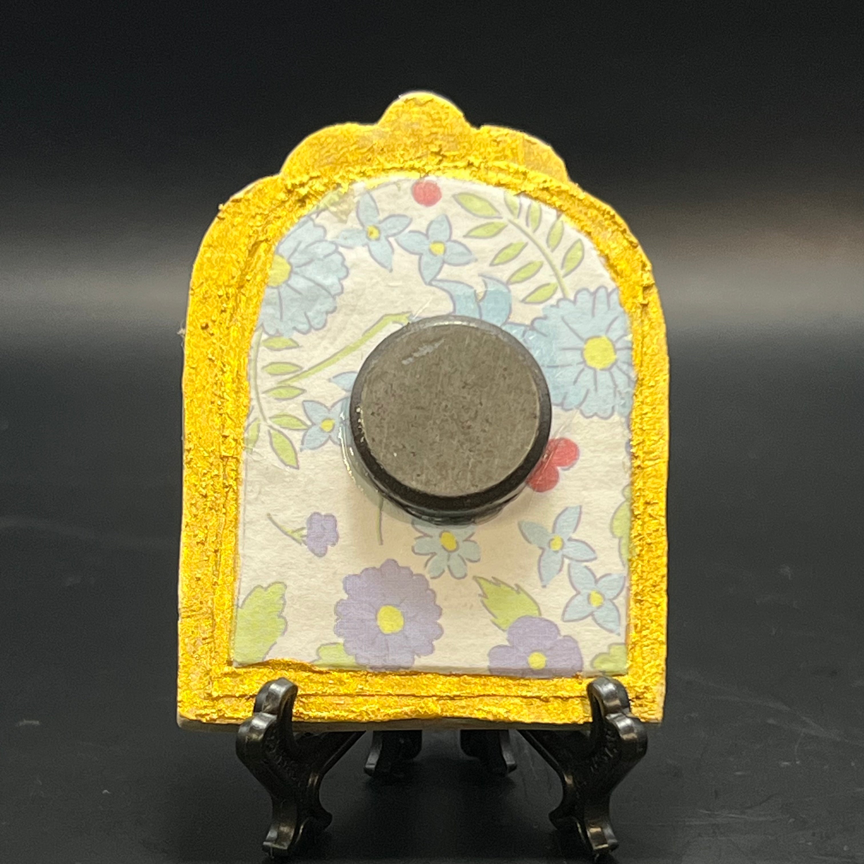 Close-up of the miniature’s textured lily petal details and subtle color variations from a top-down perspective.