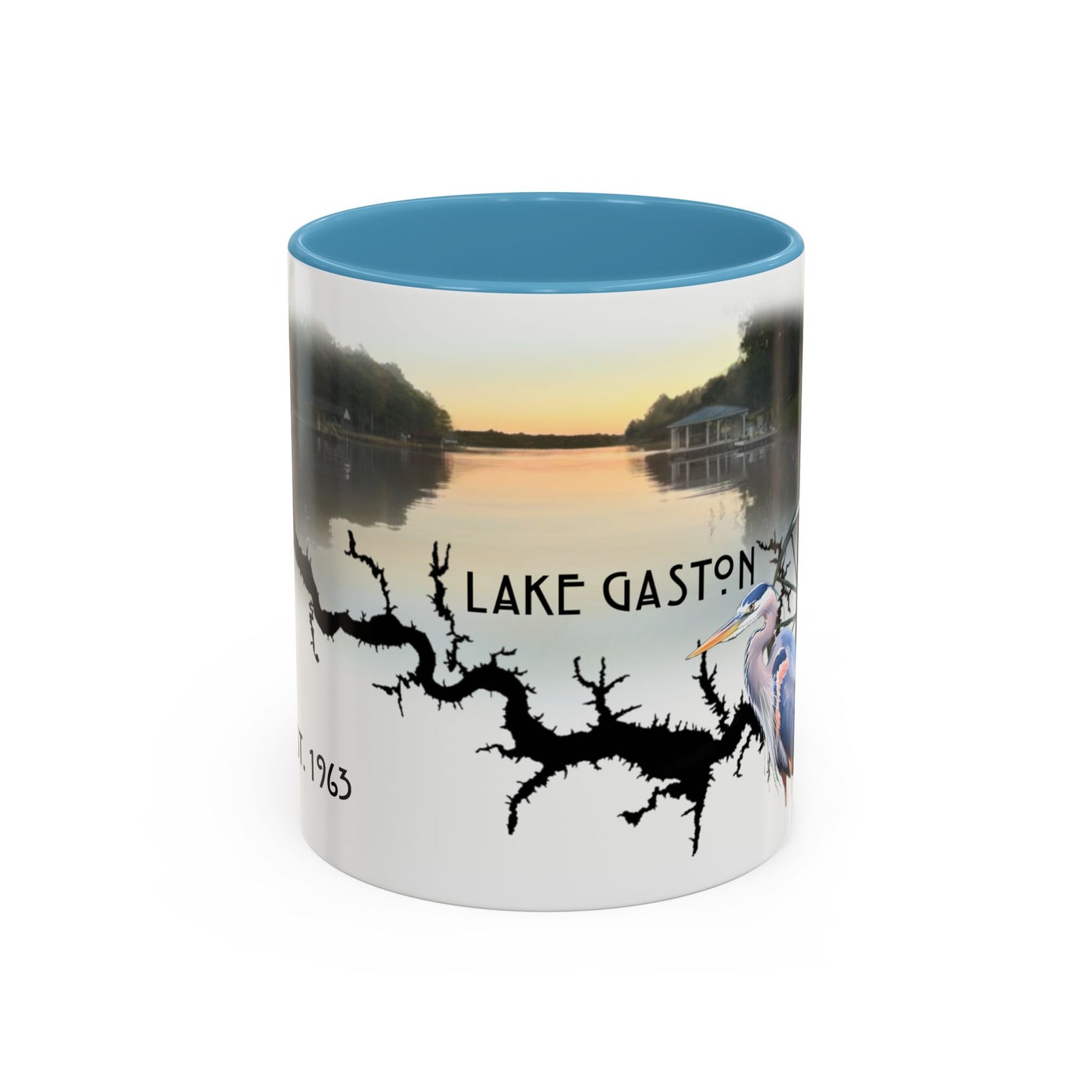 This is the 11oz Light Blue Lake Gaston Mug. It is an illustration by Lee Hansheng Studios. The picture is showing the front side of the mug. The inside of mug are color matched too. The mug is all white except for the illustration and handle. The illustration shows the lake on a horizon, the words "Lake Gaston", a black branch, and a blue heron on the right. The colors are orange, blue and green for the landscape. The mug is against a white background in the picture.