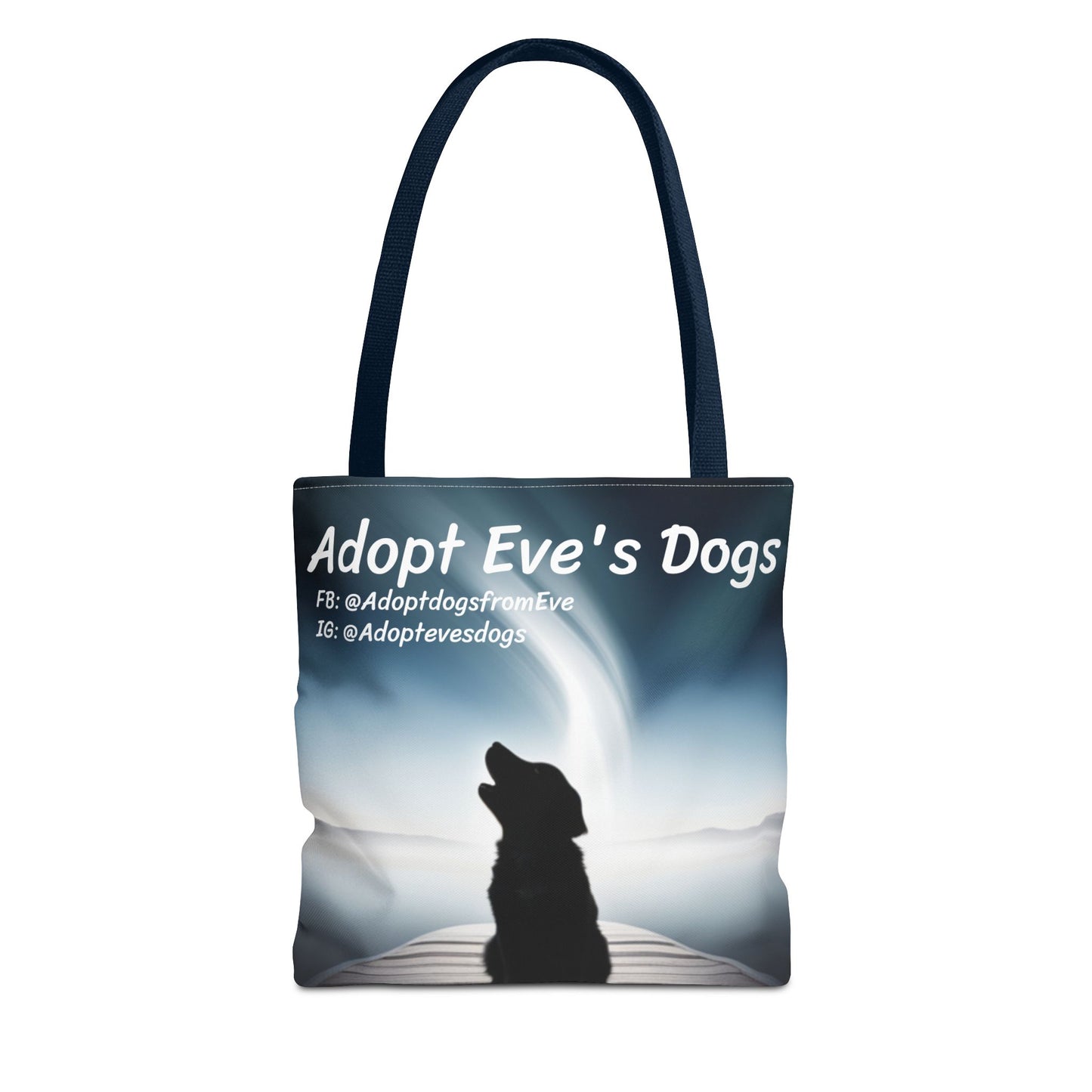 This is the Navy 13" x 13" Adopt Eve's Dogs Tote with color matched handles. This is an all around print tote with "Adopt Eve's Dogs" and socials on the top in white. The print is of a shadow of a golden retriever looking to the left on a pier towards water with mountains surrounding it. The tote is against a white background.
