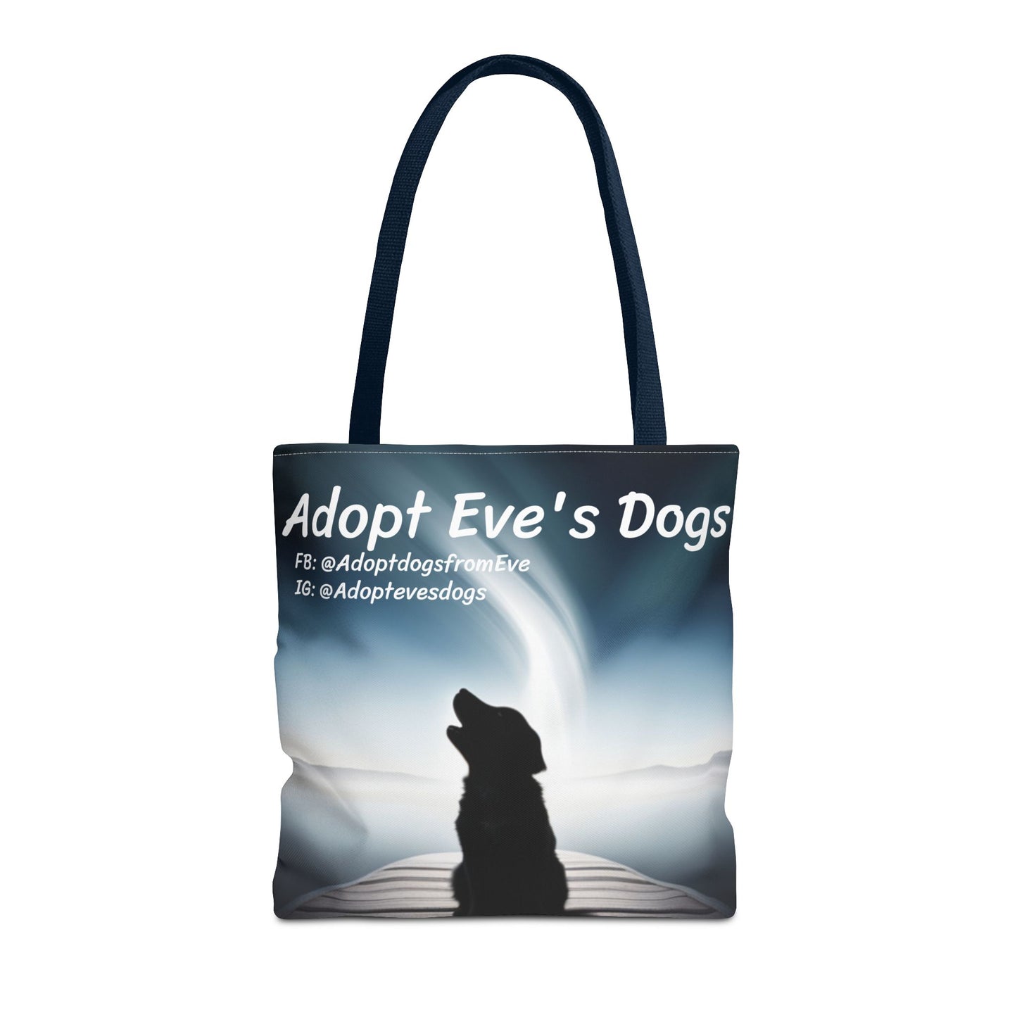 This is the Navy 16" x 16" Adopt Eve's Dogs Tote with color matched handles. This is an all around print tote with "Adopt Eve's Dogs" and socials on the top in white. The print is of a shadow of a golden retriever looking to the left on a pier towards water with mountains surrounding it. The tote is against a white background.