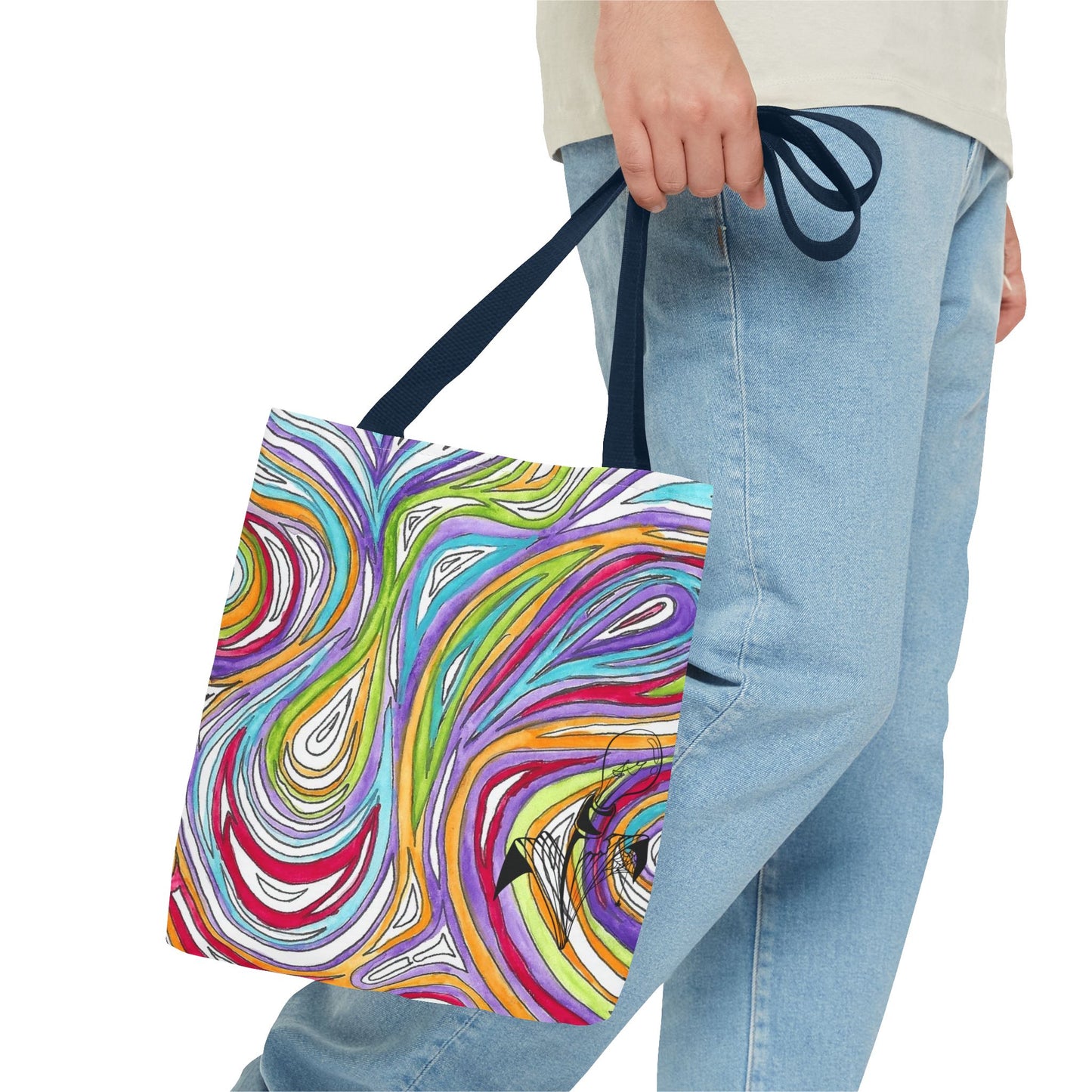This is the Navy 13" x 13" Oil Spill Tote Bag by Storm Garden Studio. The tote has color matched straps, abstract colors and line work, all over print. The colors are lime green, orange, light blue, dark red, purple, white and black. Storm Garden Studio logo printed in black on bottom right of tote bag. A gentleman wearing a white shirt, jeans and turned to the right is holding the tote by the handles. The image is from the hip down. The tote is against a white background.