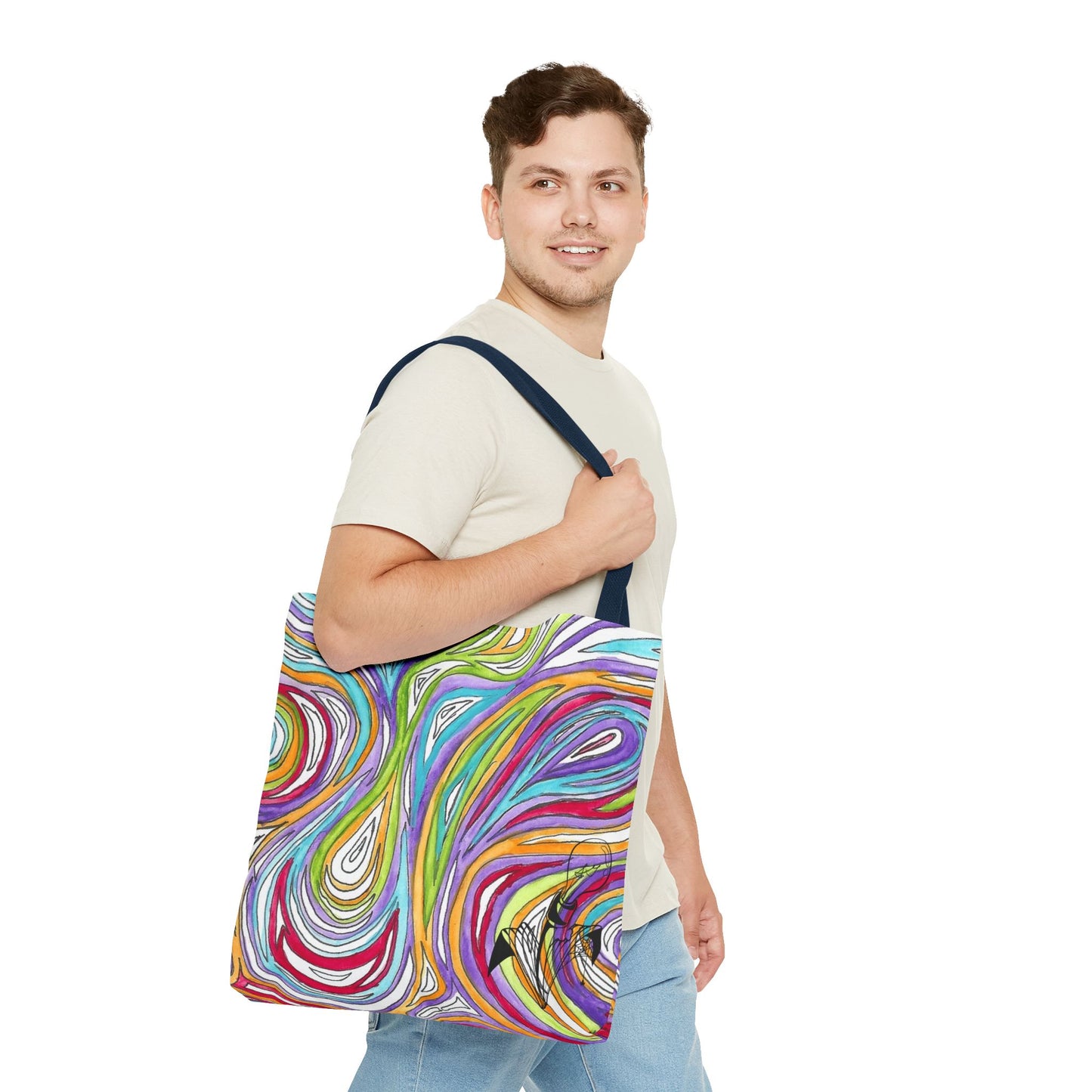 This is the Navy 18" x 18" Oil Spill Tote bag by Storm Garden Studios. Brunette man in white shirt, and blue jeans, side view walking to the right carrying the bag with color matched straps, abstract colors and line work, all over print. The colors are lime green, orange, light blue, dark red, purple, white and black. Storm Garden Studio logo printed in black on bottom right of tote bag. He is against a white background.