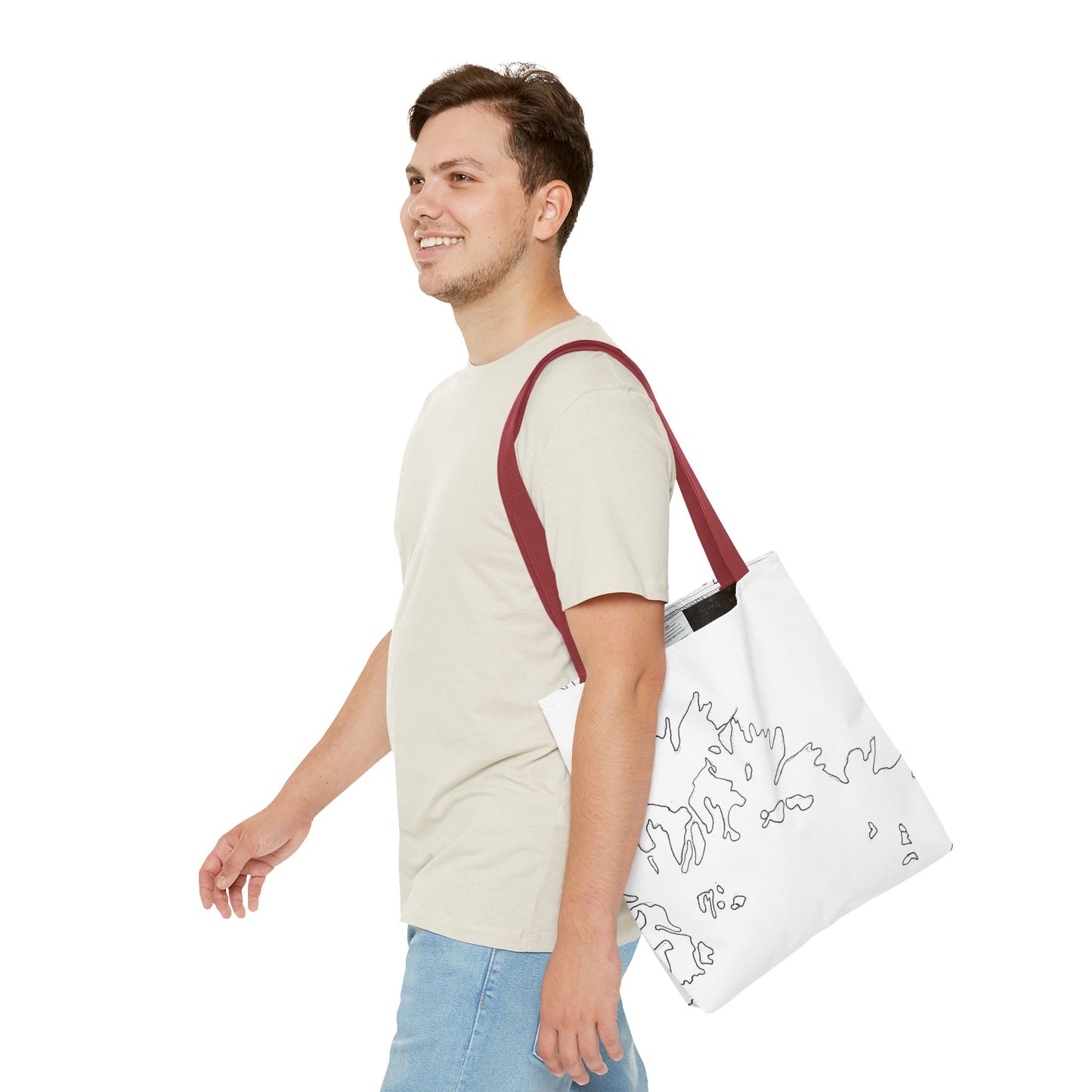 This is the Red 13" x 13" Flowers Tote Bag by Storm Garden Studio. The tote has color matched straps, abstract line work which is outlines of flowers, all over print. The colors are white and black. A brunette man is walking towards the left wearing the white tee and light jeans. He is looking towards the left and smiling with the tote over his shoulder. He is against a white background.