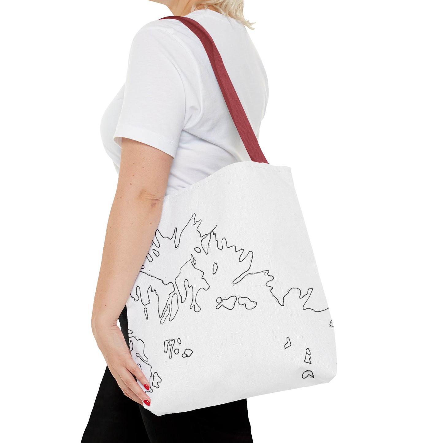 This is the Red 16" x 16" Flowers Tote Bag by Storm Garden Studio. The tote has color matched straps, abstract line work which is outlines of flowers, all over print. The colors are white and black. A blond haired lady is walking towards the left wearing a white tee, black pants, hand on the tote and image is from the shoulders down. She is against a white background.