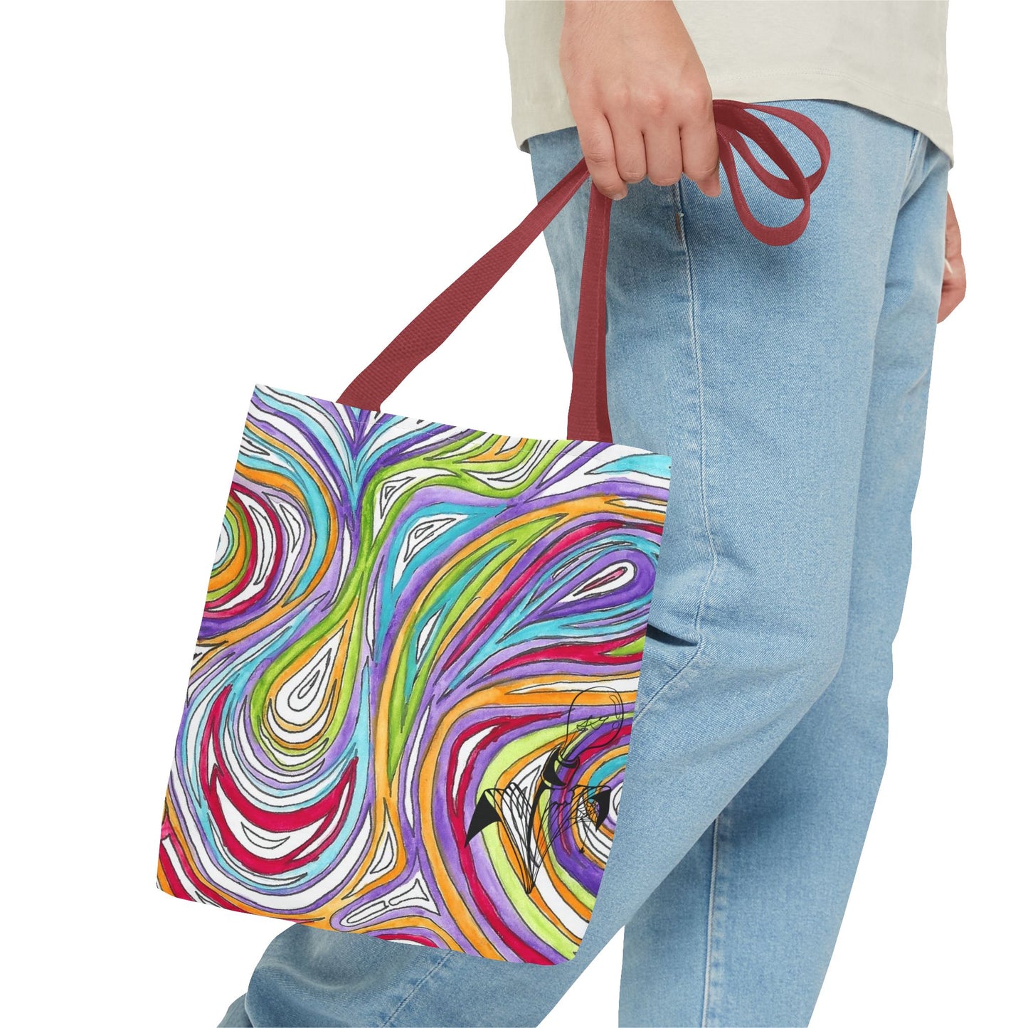 This is the Red 13" x 13" Oil Spill Tote Bag by Storm Garden Studio. The tote has color matched straps, abstract colors and line work, all over print. The colors are lime green, orange, light blue, dark red, purple, white and black. Storm Garden Studio logo printed in black on bottom right of tote bag. A gentleman wearing a white shirt, jeans and turned to the right is holding the tote by the handles. The image is from the hip down. The tote is against a white background.