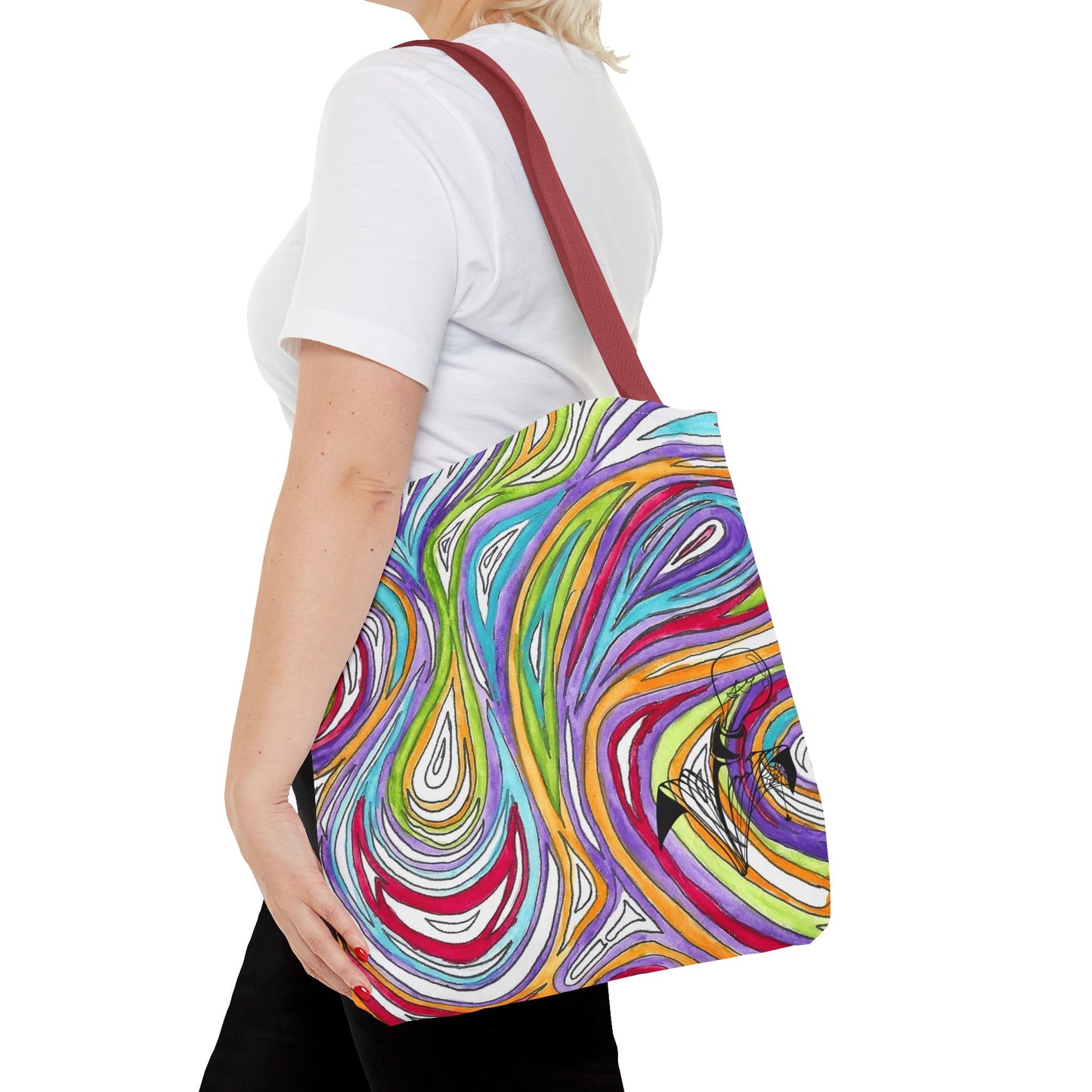 This is the Red 16" x 16" Oil Spill Tote bag by Storm Garden Studios. A woman walking towards the left, short blonde hair, in white shirt, and black pants, one hand on the tote and carrying the bag with color matched straps that is 20" x 20", abstract colors and line work, all over print. The colors are lime green, orange, light blue, dark red, purple, white and black. Storm Garden Studio logo on bottom right of tote bag printed in black. She is against a white background.