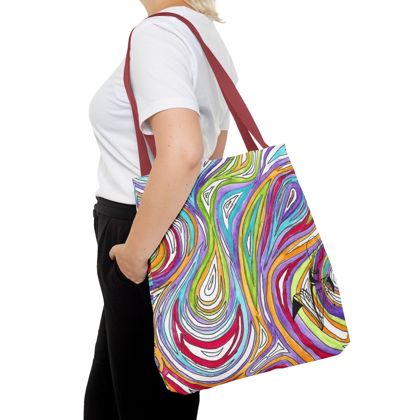 This is the Red 18" x 18" Oil Spill Tote bag by Storm Garden Studios. A woman walking towards the left, short blonde hair, in white shirt, and black pants, one hand in pant's pocket and carrying the bag with color matched straps that is 20" x 20", abstract colors and line work, all over print. The colors are lime green, orange, light blue, dark red, purple, white and black. Storm Garden Studio logo on bottom right of tote bag printed in black. She is against a white background.