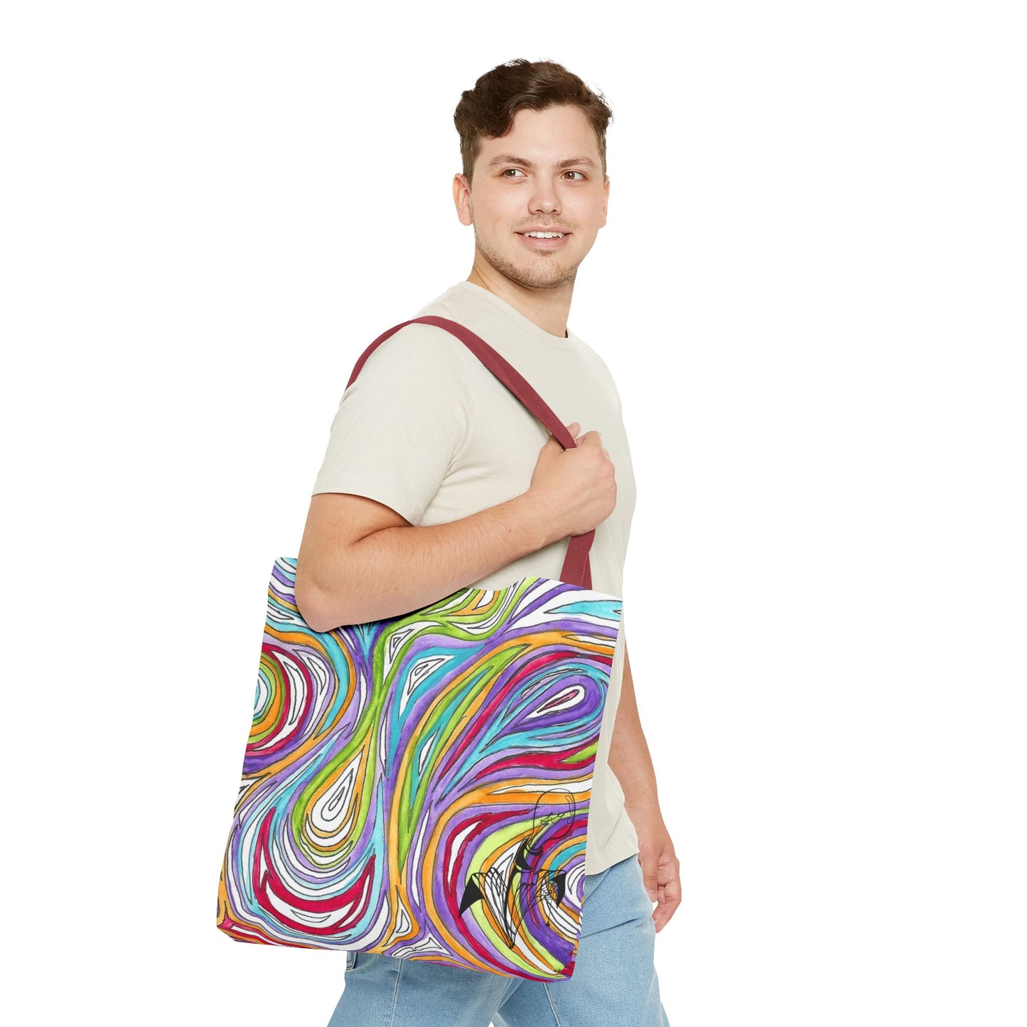This is the Red 18" x 18" Oil Spill Tote bag by Storm Garden Studios. Brunette man in white shirt, and blue jeans, side view walking to the right carrying the bag with color matched straps, abstract colors and line work, all over print. The colors are lime green, orange, light blue, dark red, purple, white and black. Storm Garden Studio logo printed in black on bottom right of tote bag. He is against a white background.