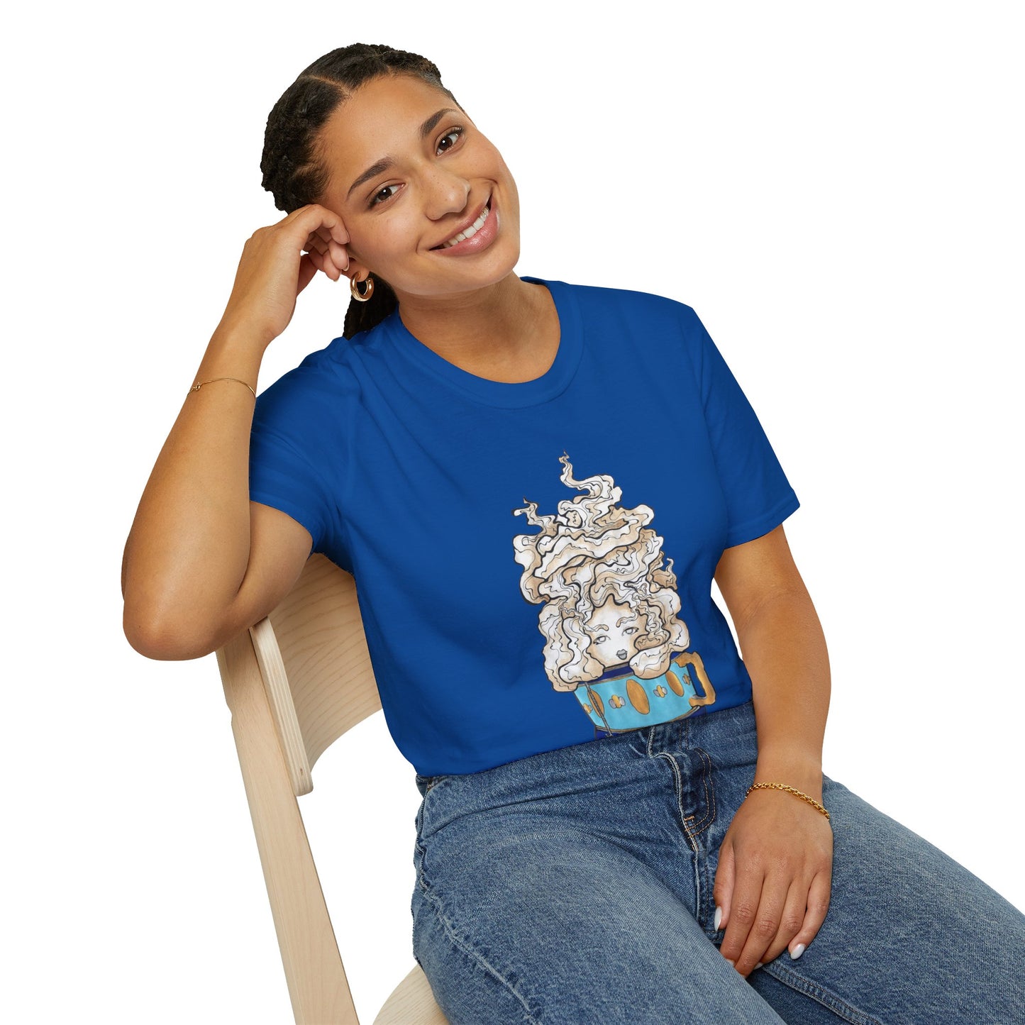This is the Royal Earl Grey Softstyle T-Shirt by Chris Foster Design. It comes in sizes XS-5XL. The illustration is of a gold, light blue and dark blue teacup with a tan, yellow and white steam. The steam is swirly and goes up and outwards. In the middle is a lady's face. A smiling lady is sitting on a light wood chair with the backrest to the left, elbow on the back rest, dark jeans, looking to the front and wearing the t-shirt.