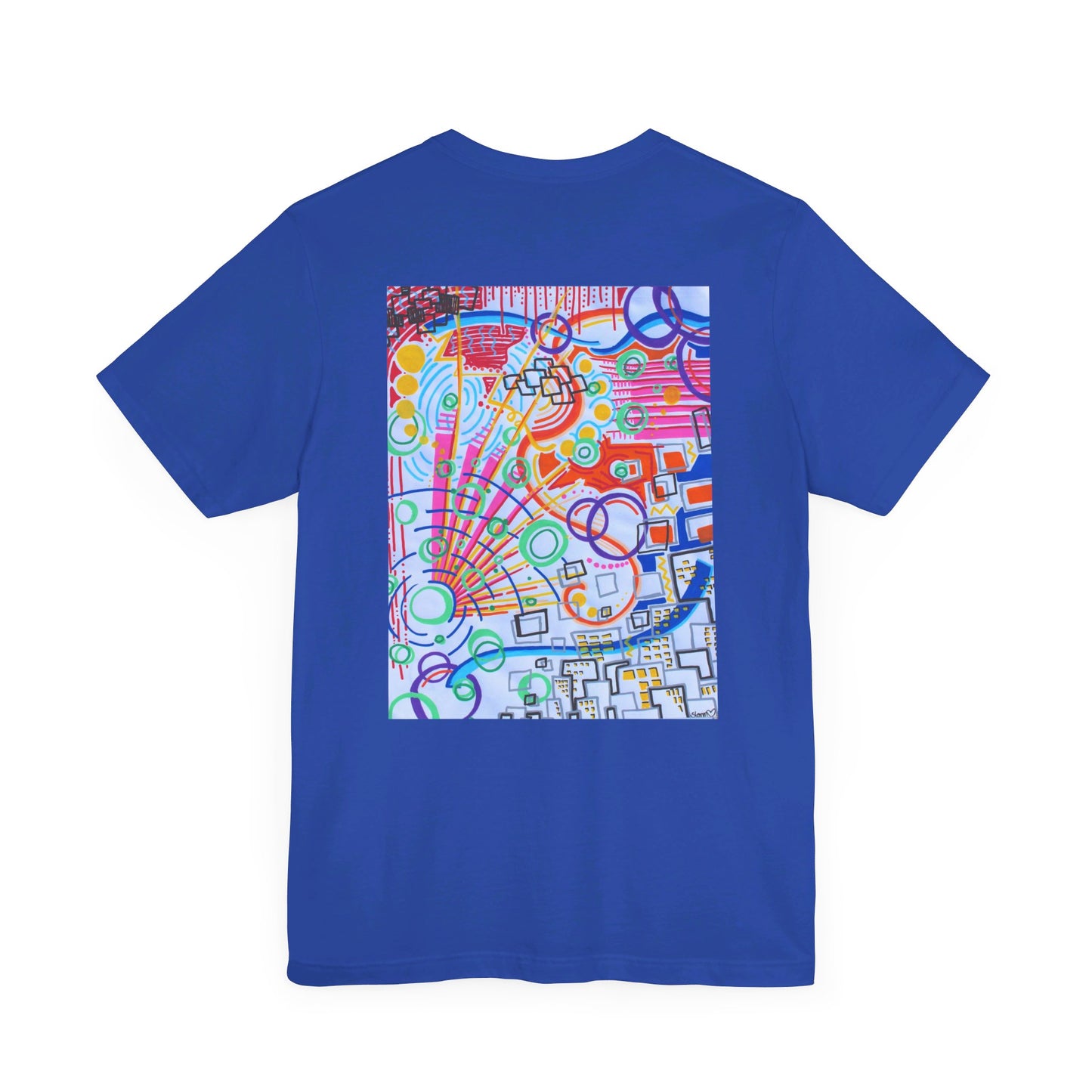 This is the True Royal The City Jersey T-Shirt by Storm Garden Studio. This showcases the back of the shirt. The image is from the upper back to the mid waist. The illustration is rectangular shaped and has a multitude of colors like blue, red, pink, yellow, green and light blue. It is an abstract image with building shapes, circles and squiggles. This is against a white background.