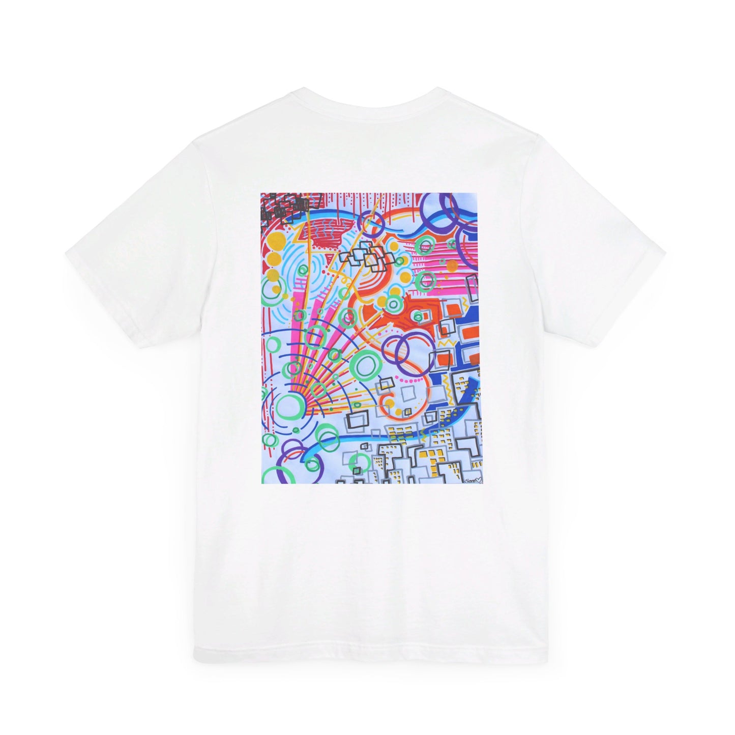 This is the White The City Jersey T-Shirt by Storm Garden Studio. This showcases the back of the shirt. The image is from the upper back to the mid waist. The illustration is rectangular shaped and has a multitude of colors like blue, red, pink, yellow, green and light blue. It is an abstract image with building shapes, circles and squiggles. This is against a white background.