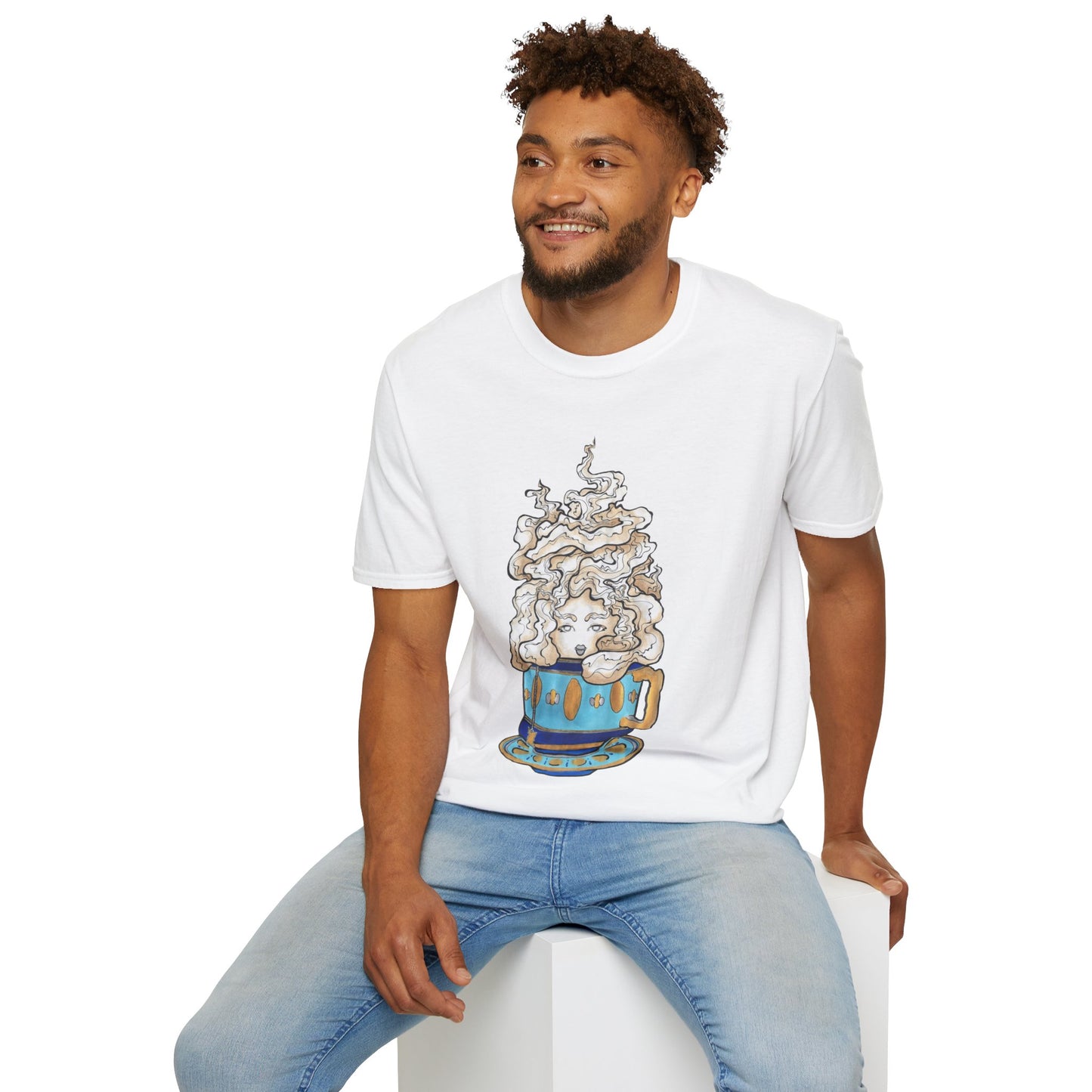 This is the White Earl Grey Softstyle T-Shirt by Chris Foster Design. It comes in sizes XS-5XL. The illustration is of a gold, light blue and dark blue teacup with a tan, yellow and white steam. The steam is swirly and goes up and outwards. In the middle is a lady's face. A smiling man sitting on a white podium with one hand on the back edge, light jeans, looking to the left and wearing the t-shirt.