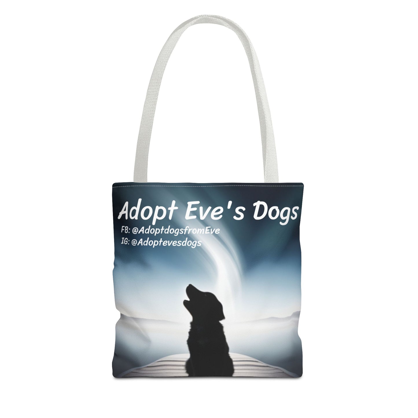 This is the White 13" x 13" Adopt Eve's Dogs Tote with color matched handles. This is an all around print tote with "Adopt Eve's Dogs" and socials on the top in white. The print is of a shadow of a golden retriever looking to the left on a pier towards water with mountains surrounding it. The tote is against a white background.