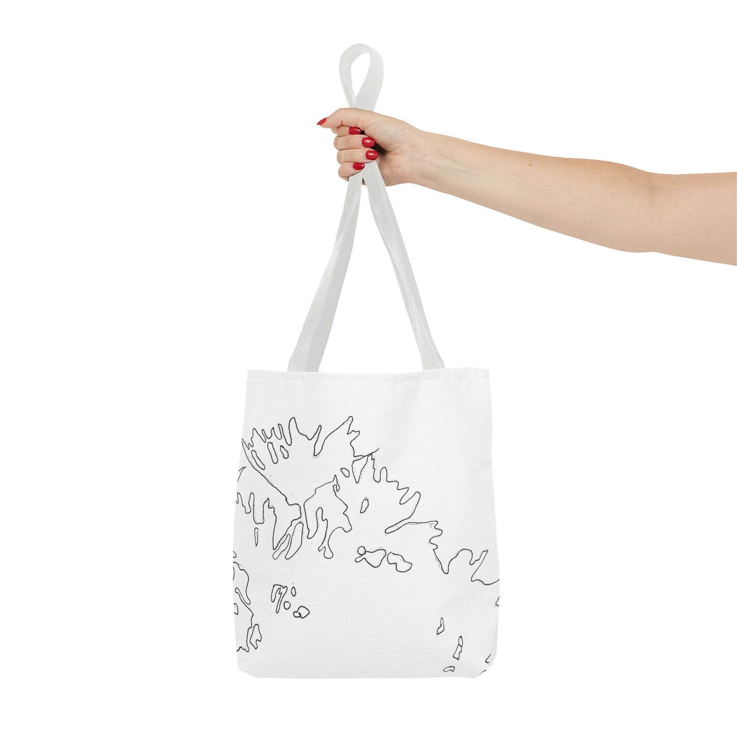 This is the White 13" x 13" Flowers Tote Bag by Storm Garden Studio. The tote has color matched straps, abstract line work which is outlines of flowers, all over print. The colors are white and black. A lady's upper arm is to the left and a hand stretched out holding the handles of the tote in the middle. The tote is against a white background.