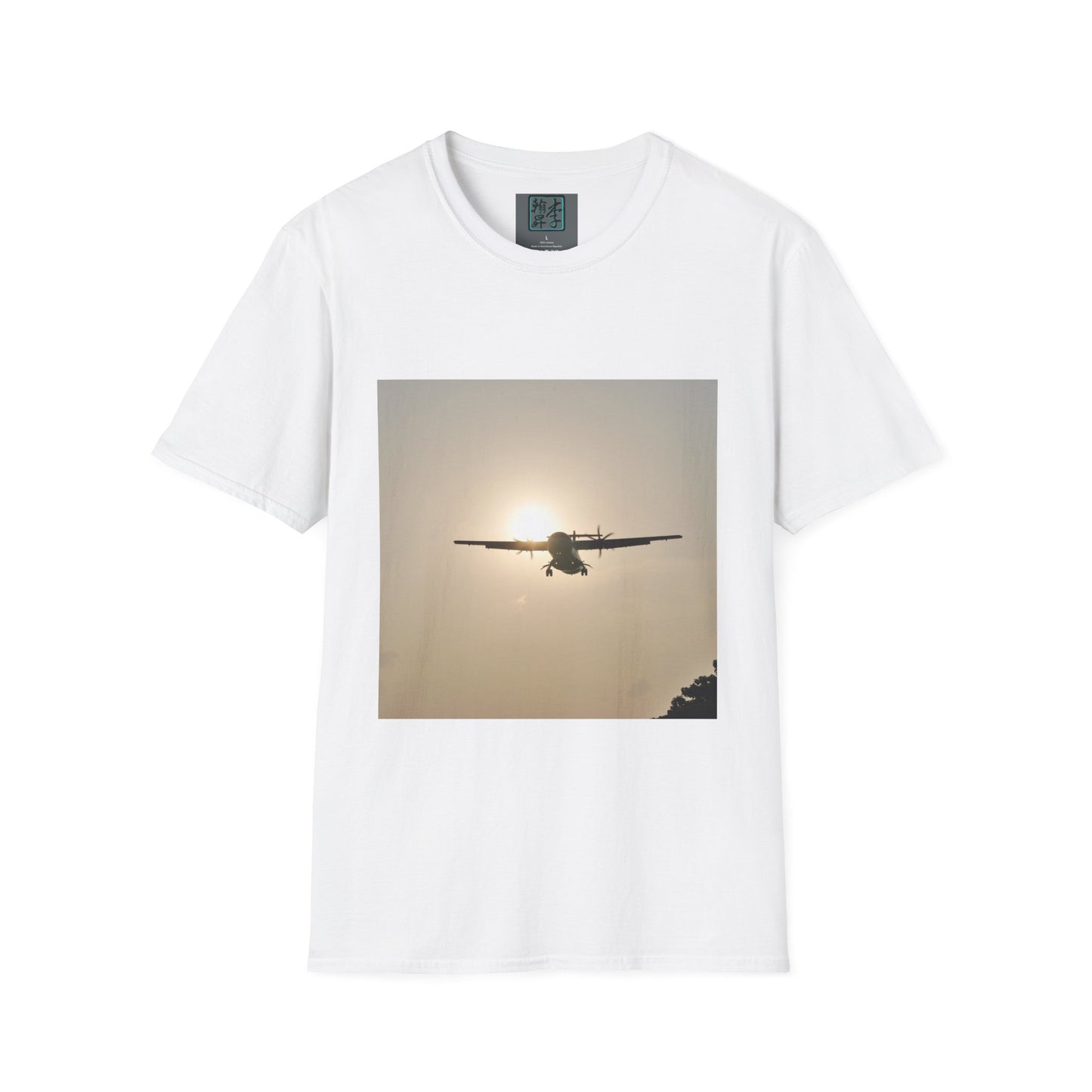 This is the White Landing T-Shirt by Lee Hansheng Studios. This is an image of the front folded. On the inside of the shirt is the logo for the studio printed in black outlined in blue, gray size label with the print being white. The illustration is a rectangular design of an airplane landing. There is an orange/yellow sun with the shadowed plane. Some trees on the right end corner. The shirt is against a white background.