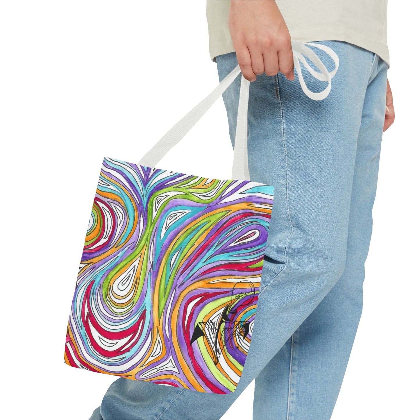 This is the White 13" x 13" Oil Spill Tote Bag by Storm Garden Studio. The tote has color matched straps, abstract colors and line work, all over print. The colors are lime green, orange, light blue, dark red, purple, white and black. Storm Garden Studio logo printed in black on bottom right of tote bag. A gentleman wearing a white shirt, jeans and turned to the right is holding the tote by the handles. The image is from the hip down. The tote is against a white background.