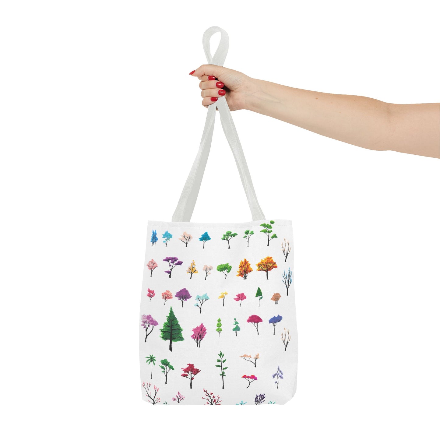 The White 16" x 16" Study of Trees Tote with color matched handles by Lee Hansheng Studios. There are a variety of tree illustrations from blooming fruit trees to deciduous and evergreens. The trees are colored pinks, purples, greens, yellows, blues and oranges on a white background tote. A woman's hand with red nail polish is grabbing the handles. Her arm is outstretched to the middle. The tote is against a white background.