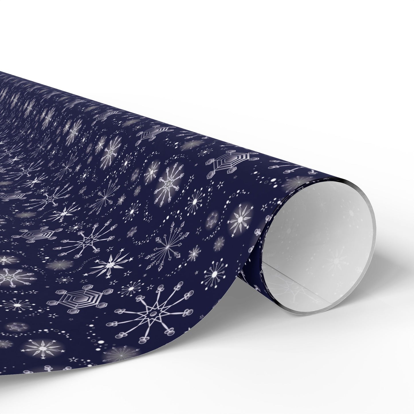 This is the glossy 30" x 72" Winter Blizzard Gift Wrap. The image is a roll of wrapping paper and the design at an angle. The background is white. The design are different types of snowflakes with different sizes of circles within each flake. The wrapping paper is dark blue and the snowflakes and design are all white.