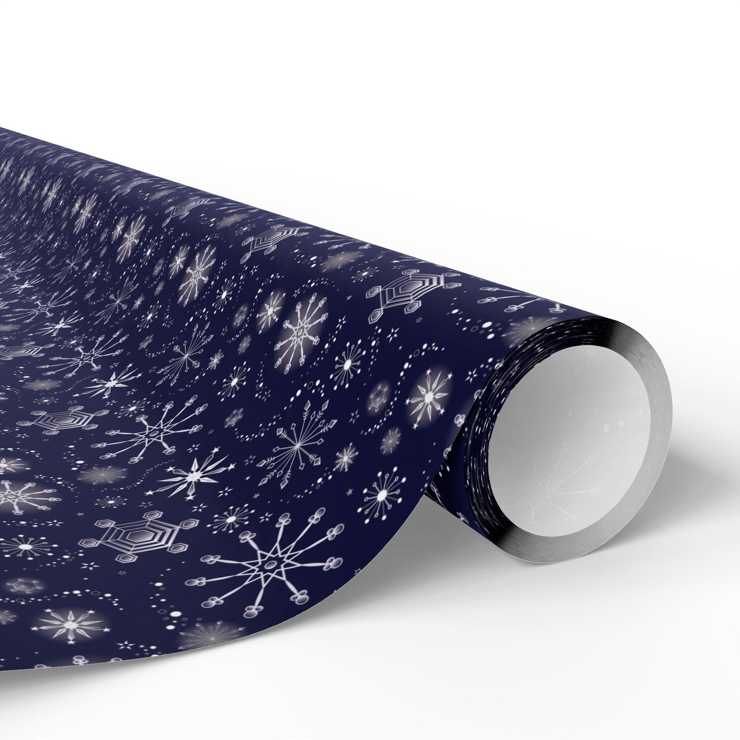 This is the matte 30" x 72" Winter Blizzard Gift Wrap. The image is a roll of wrapping paper and the design at an angle. The background is white. The design are different types of snowflakes with different sizes of circles within each flake. The wrapping paper is dark blue and the snowflakes and design are all white.
