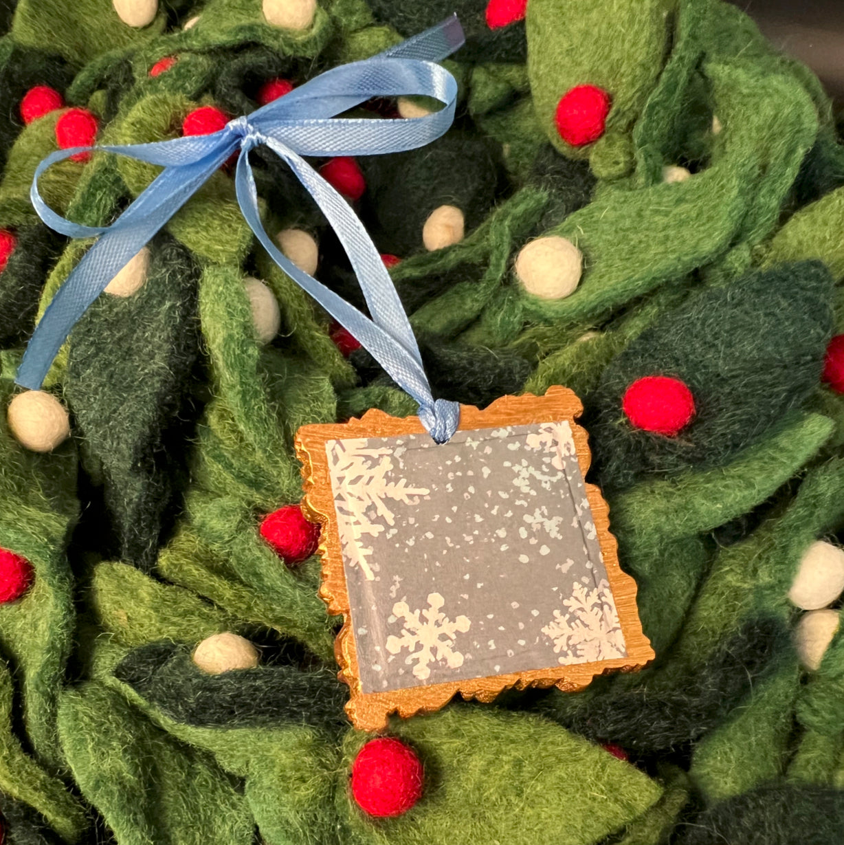 Close-up of the snowflake design’s intricate laser-etched fine lines on the ornament’s frosted glass surface.