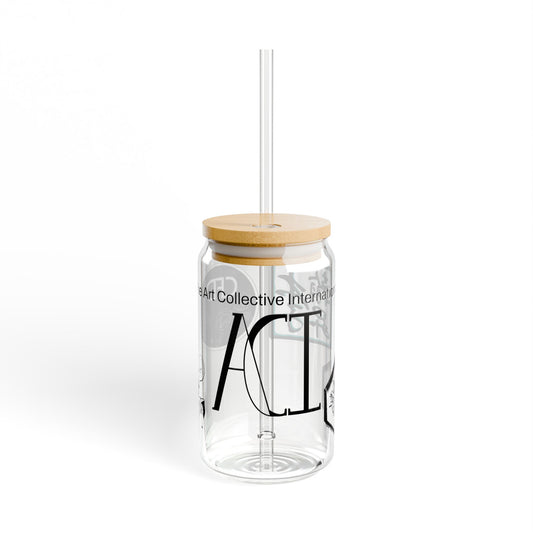 This is the ACI Sipper with a lid and straw. The lid is bamboo and there is a Tritan plastic straw. This shows the front side of the clear glass and features the ACI logo and "The Art Collective International" surrounds the glass. The Chris Foster Design and Lee Hansheng Studios are seen on the other side of the glass.