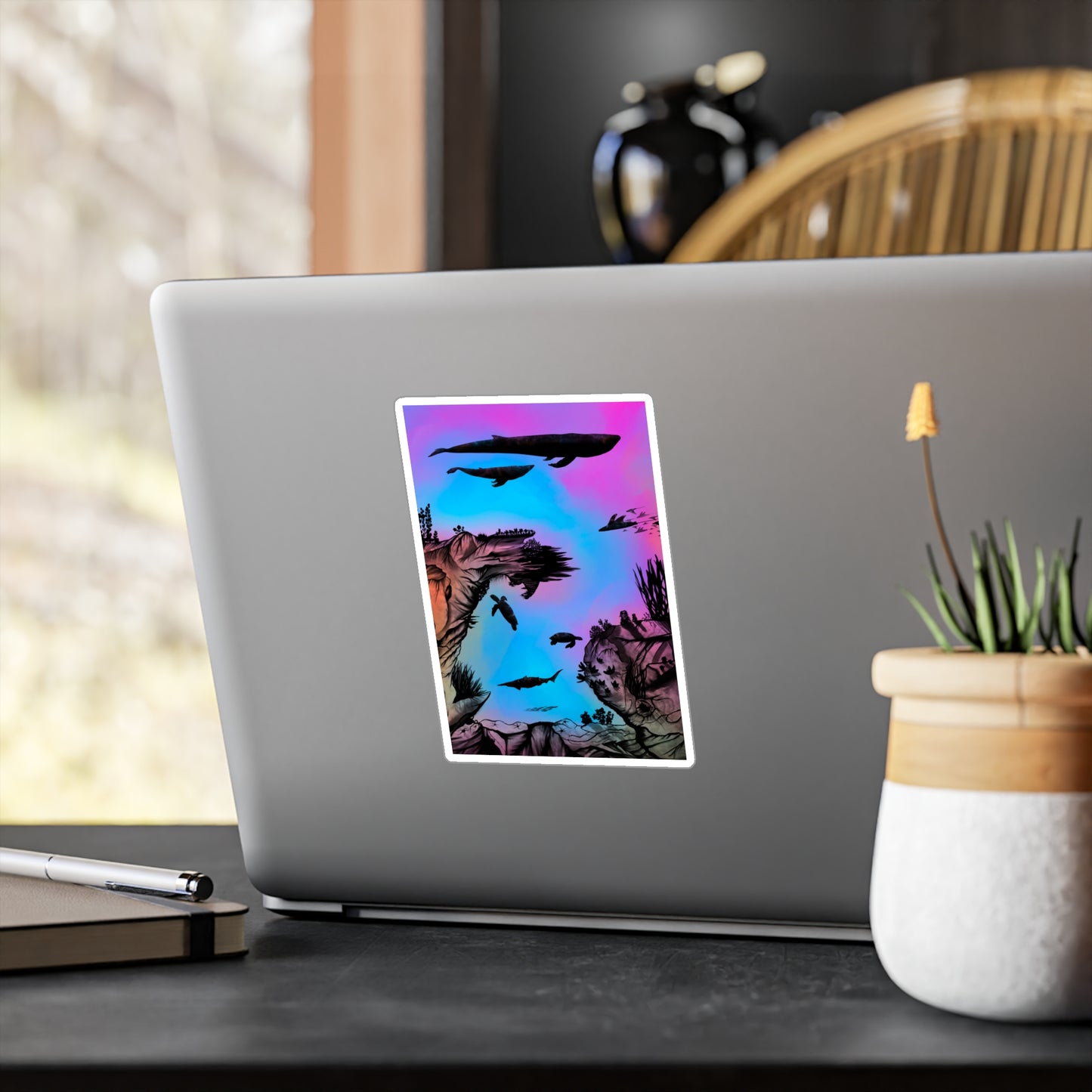 A 4" x 6" kiss-cut vinyl decal underwater seascape with aquatic plants on a marbled background. There are two blue whales, 1 goblin shark, school of eagle rays, two sea turtles and a school of fish on a laptop. 