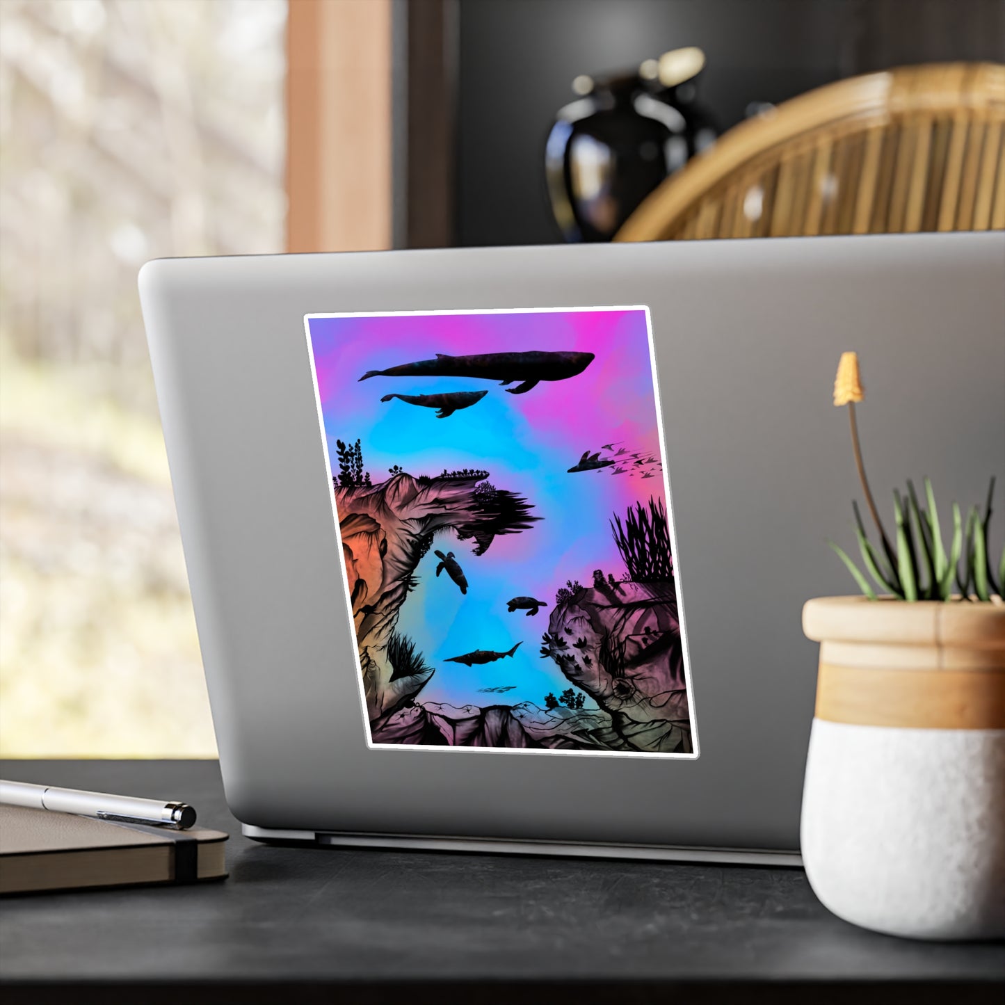 A 6" x 8" kiss-cut vinyl decal underwater seascape with aquatic plants on a marbled background. There are two blue whales, 1 goblin shark, school of eagle rays, two sea turtles and a school of fish on a laptop. There is a haworthia that is going to bloom in the foreground plus a journal and pen on the left.