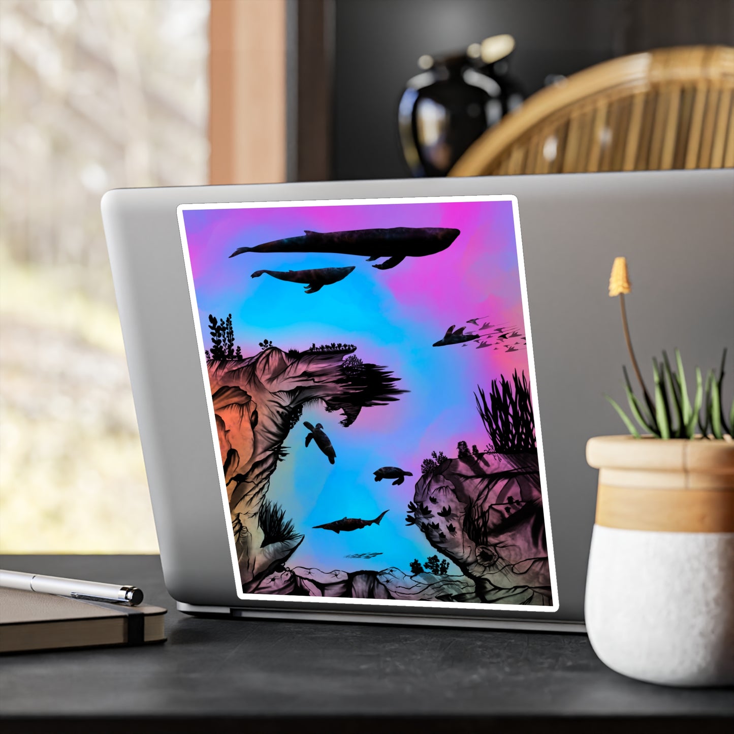 A 8" x 10" kiss-cut vinyl decal underwater seascape with aquatic plants on a marbled background. There are two blue whales, 1 goblin shark, school of eagle rays, two sea turtles and a school of fish on a laptop.