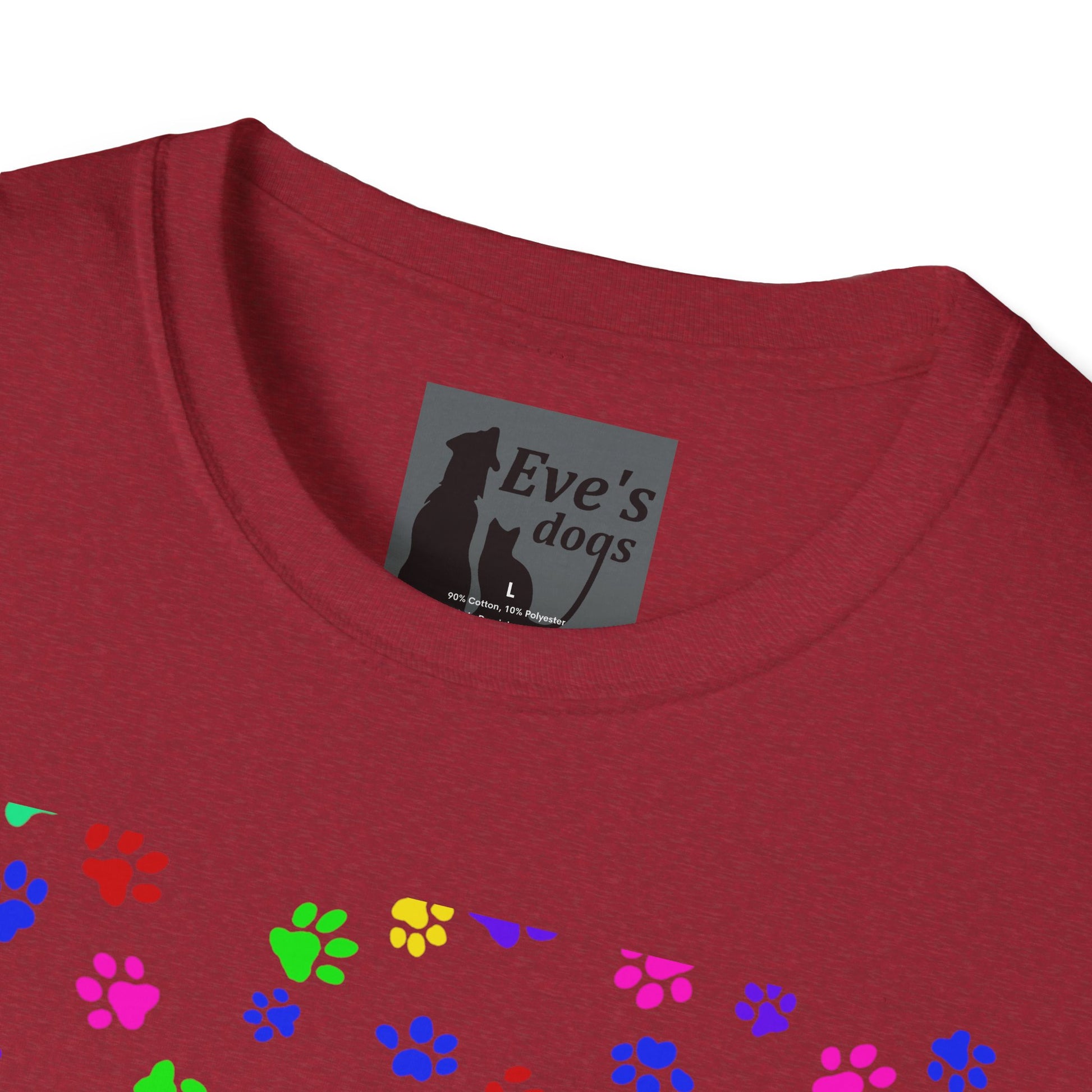 This is the Antique Cherry Red Adopt Eve's Dogs T-Shirt. It comes in XS - 5XL. This is an upclose image of the shirt where the neck/tag is. The size label is a grey and black tag with a dog and cat with the "Eve's dogs" writing. The sizes and shirt product materials are printed in white. There is a little bit of paw prints on the front.  The colors are pink, green, blue, purple, red paw prints in different sizes. It is against a white background.