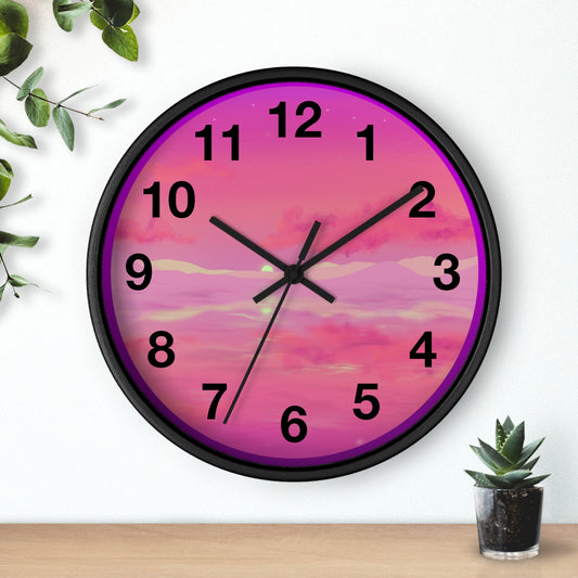 This is the 10" Black Base Pink Dreamscape Wall Clock with black hands by Lee Hansheng Studios.The front of the image with two black clock hands, numerals and the illustration behind it.The illustration has the sky and clouds. Different pinks and hues blended into the clouds and spreads outwards.There are dark purples on the side and yellows near the middle of the art piece. It is on a white background with leaves to the left, succulent plan on the right with a wooden board. 
