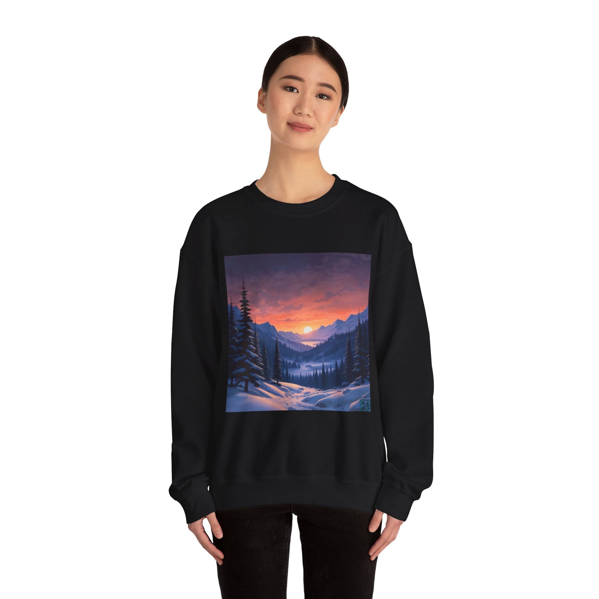 This is the Black Snow Valley Sweatshirt that is a crewneck coming in S - 5XL sizes. It is worn by an Asian lady who has black hair tied in a bun, black pants and is standing against a white background with a smile. This design is by Lee Hansheng Studios and showcases a snowy hill/mountain area with large pine trees on both sides continuing into the horizon. The sun is rising past the horizon and consist of yellow, orange, red hues which is illuminated onto the clouds, snowy field, mountains and trees. 