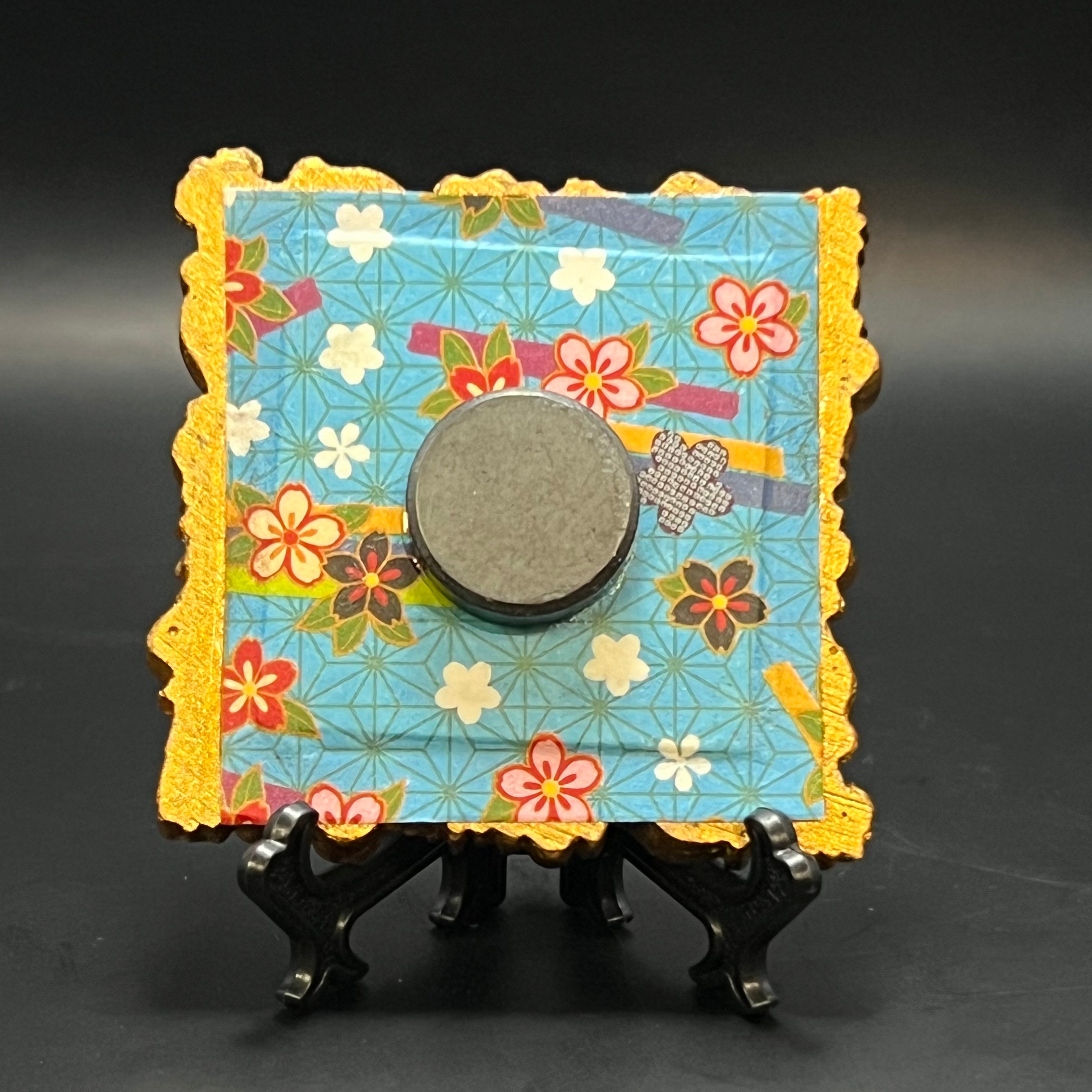 Close-up of the textured brushstrokes highlighting blue plaid stars on the mini painting’s corner detail