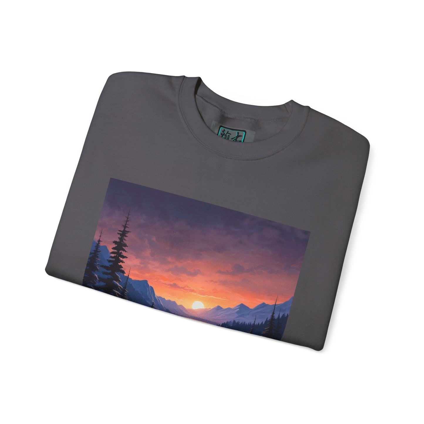 This is the Charcoal Snow Valley Sweatshirt that is a crewneck coming in S - 5XL sizes. The crewneck is folded and against a white background. This design is by Lee Hansheng Studios and showcases the sun rising past the horizon and consist of yellow, orange, red hues which is illuminated onto the tips of the dark green pine trees and the wispy clouds. Further in the background the mountain tops line the horizon. The size label is printed on the inside with the studio logo outlined in blue and black.